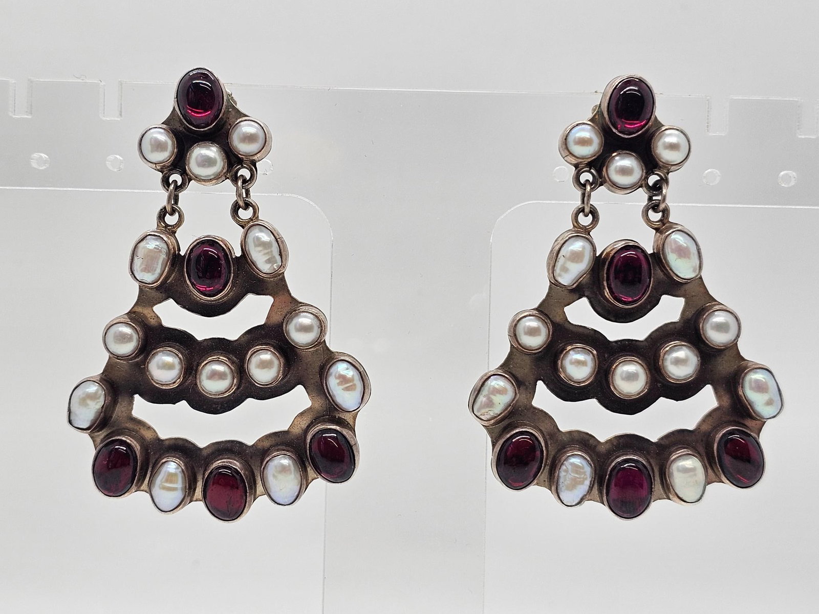 Nakai Navajo Silver Pearl & Garnet Earrings: The earrings are marked by the Navajo Native American artist "Nakai" and features a grouping of polished pearls & red Garnet inset into sterling silver. Measures 2.25"W x 1.5"T Weight: 28.3 grams