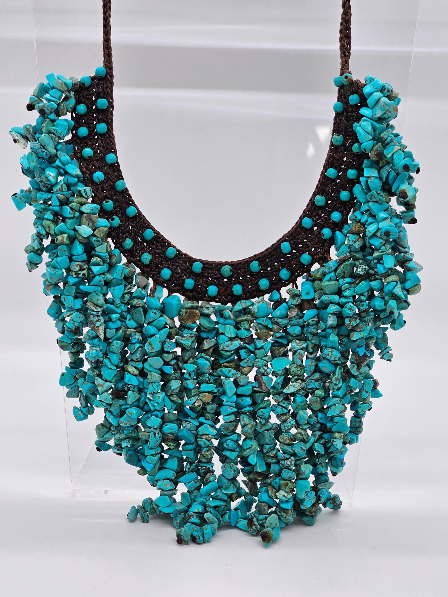 Hand Beaded Turquoise Necklace: The necklace has dozens of hanging strands of Turquoise stones all appears to be hand beaded and set into a woven cloth strap. Appears to be vintage in age, measures 17" long
