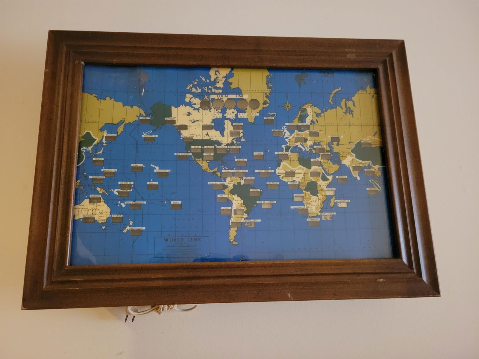 Mid-Century "World Time" Lighted Wall Clock: The clock is in good vintage condition, dated 1959 on the front. Made by Howard Miller, model number 4625. The clock is lighted from the back and appears to function during our limited test, however a