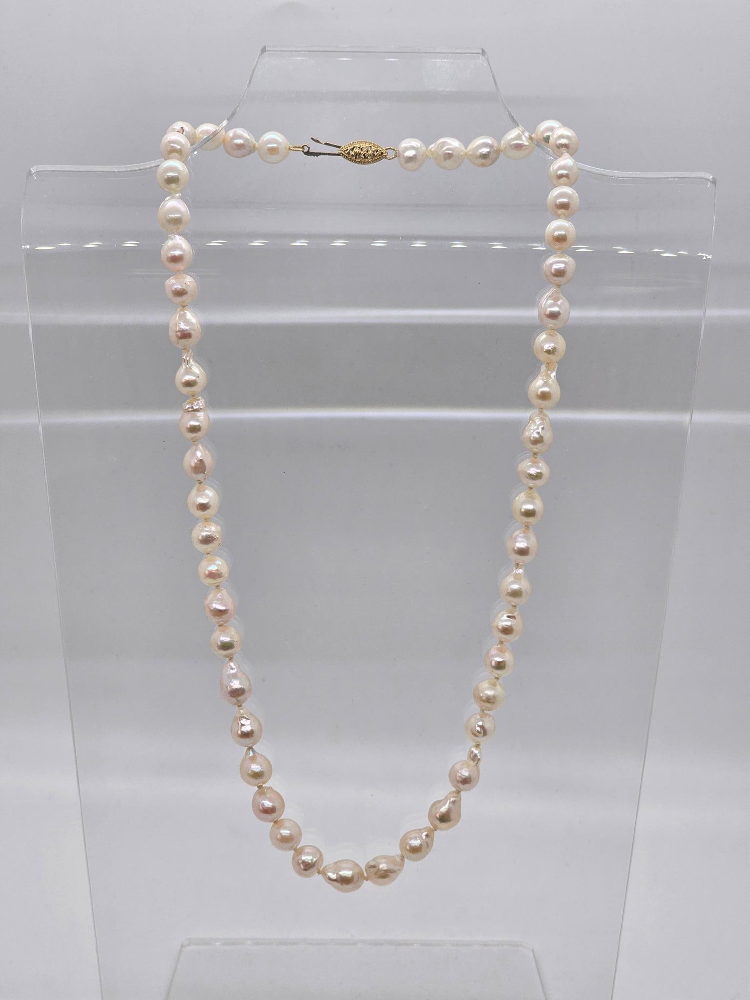 Single Strand Baroque Pearl Necklace w/ 14K Clasp: This lot includes a beautiful single strand of Baroque pearl necklace, hand knotted and in overall good vintage condition. The yellow gold clasp is marked 14k, 18" long.