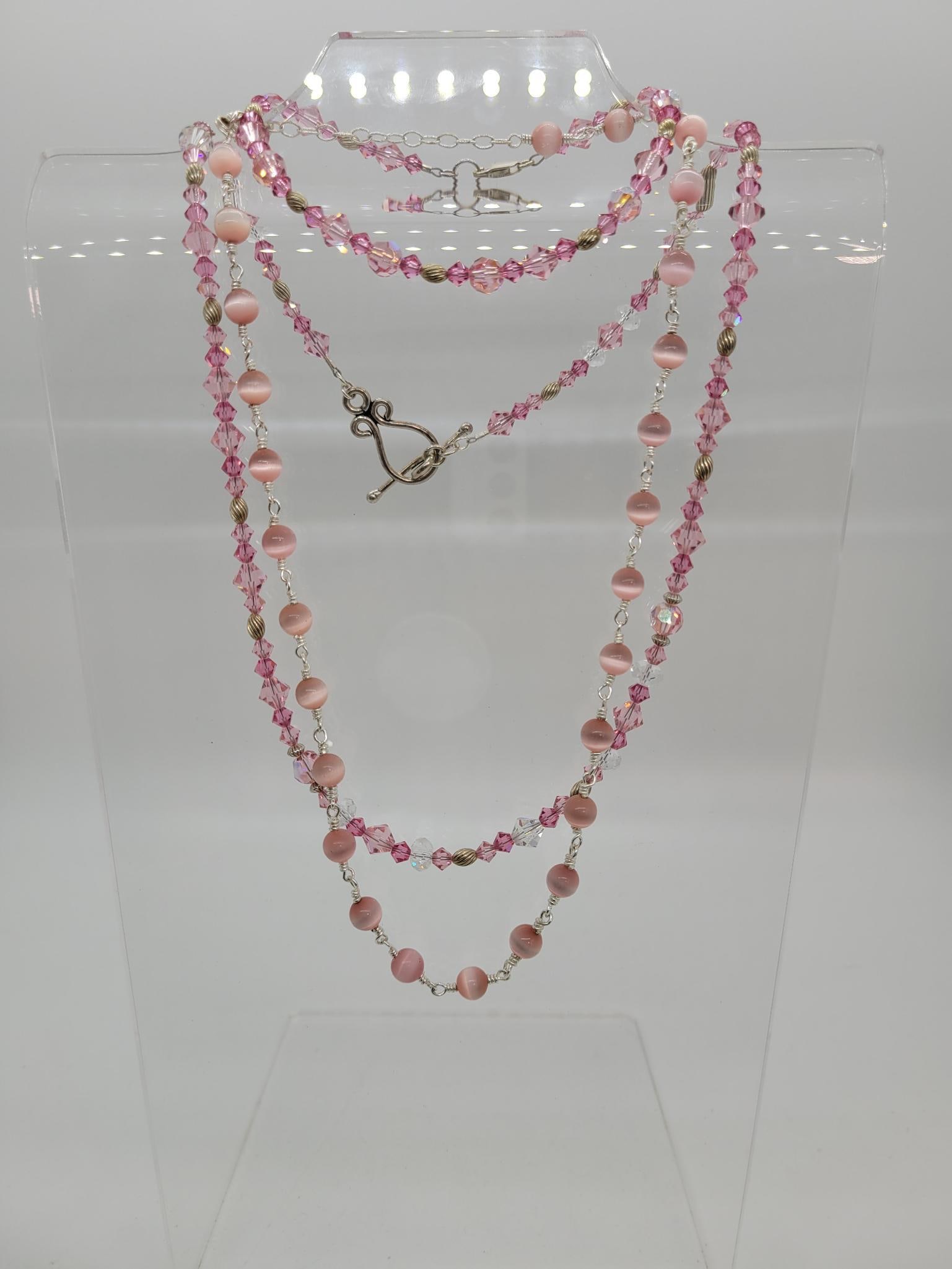 Pretty in Pink Set In Silver Lot: Description: Pretty in pink and silver featuring matching 50s crystal necklace and bracelet set in silver and a pink cats eye bead ball necklace