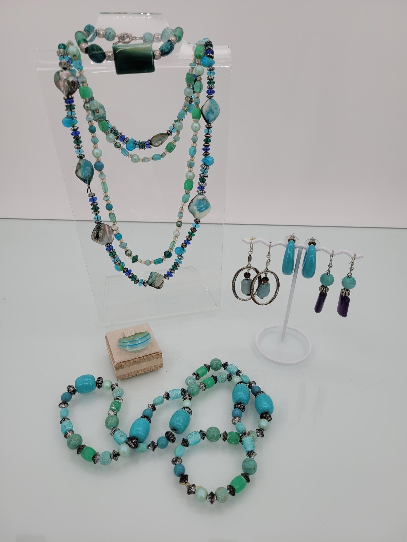 Ocean Blue Beaded Jewelry Lot: Description: this beautiful beaded lot in sublime greens and blues comes with three necklaces, one glass ring, three pairs of earrings and one hook eye beaded bracelet