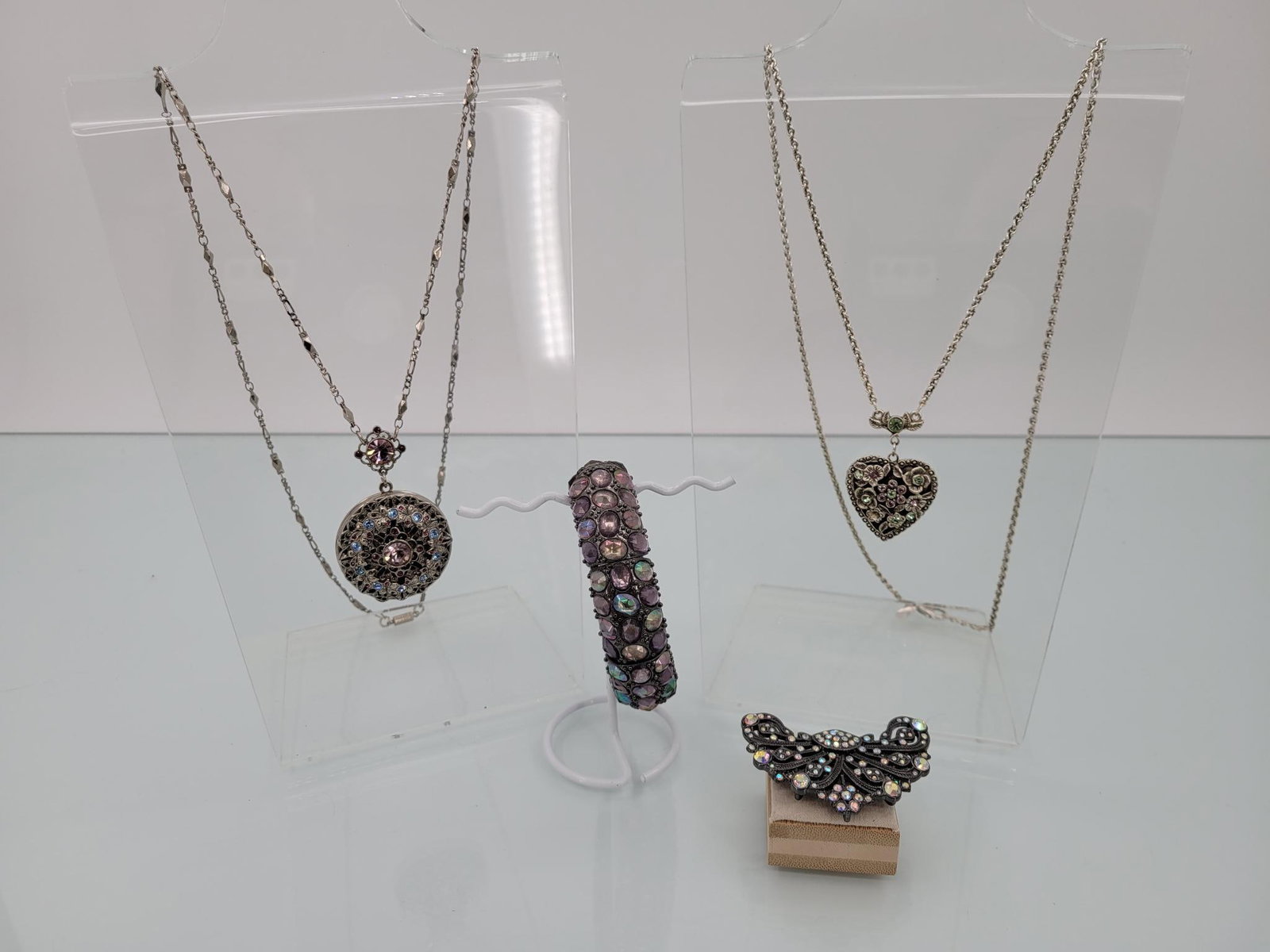 Four Piece Champagne Crystal Jewelry Lot: Description: Lot comes with beautiful lavender, opalescent, pink and blue crystal crusted pin (that can also double as a pendent) two lockets on extra long chains and an elastic bangle