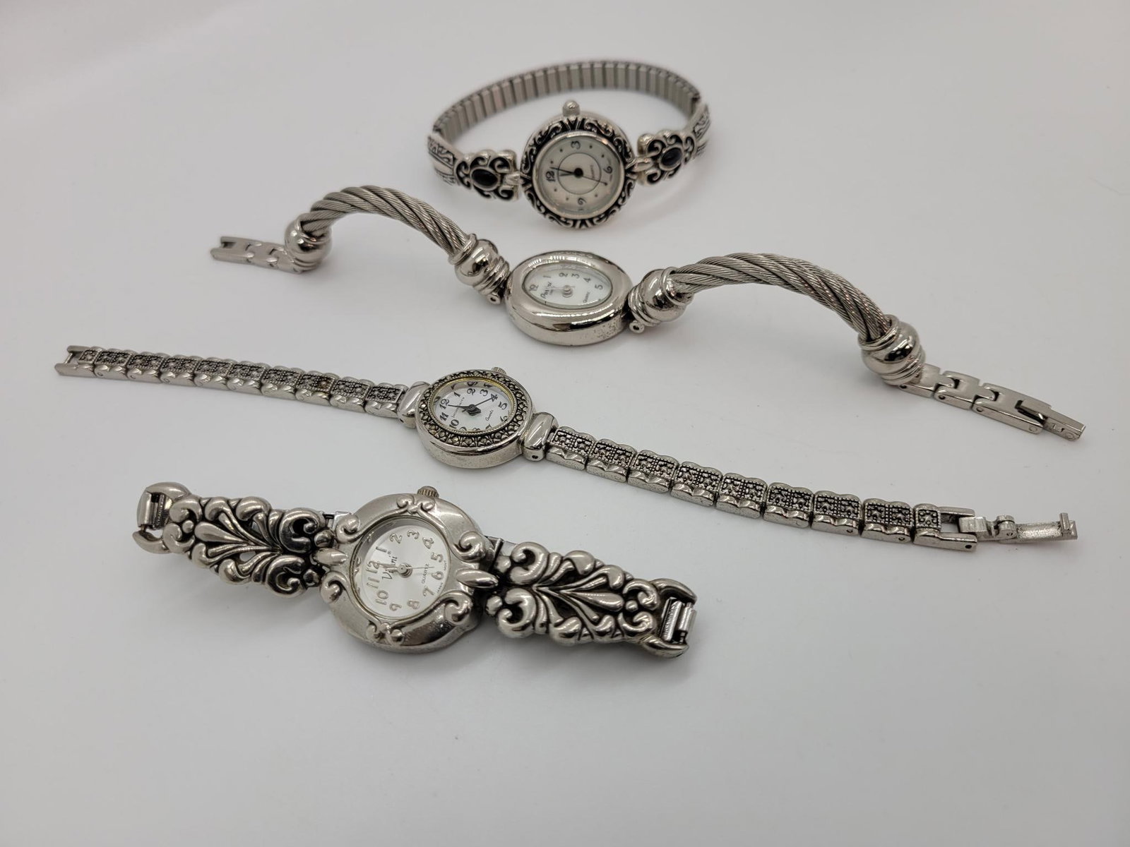 Quad Of Women's Silver Toned Watches: Description: Four women's silver toned wristwatches, two have beautiful mother of pearl faces
