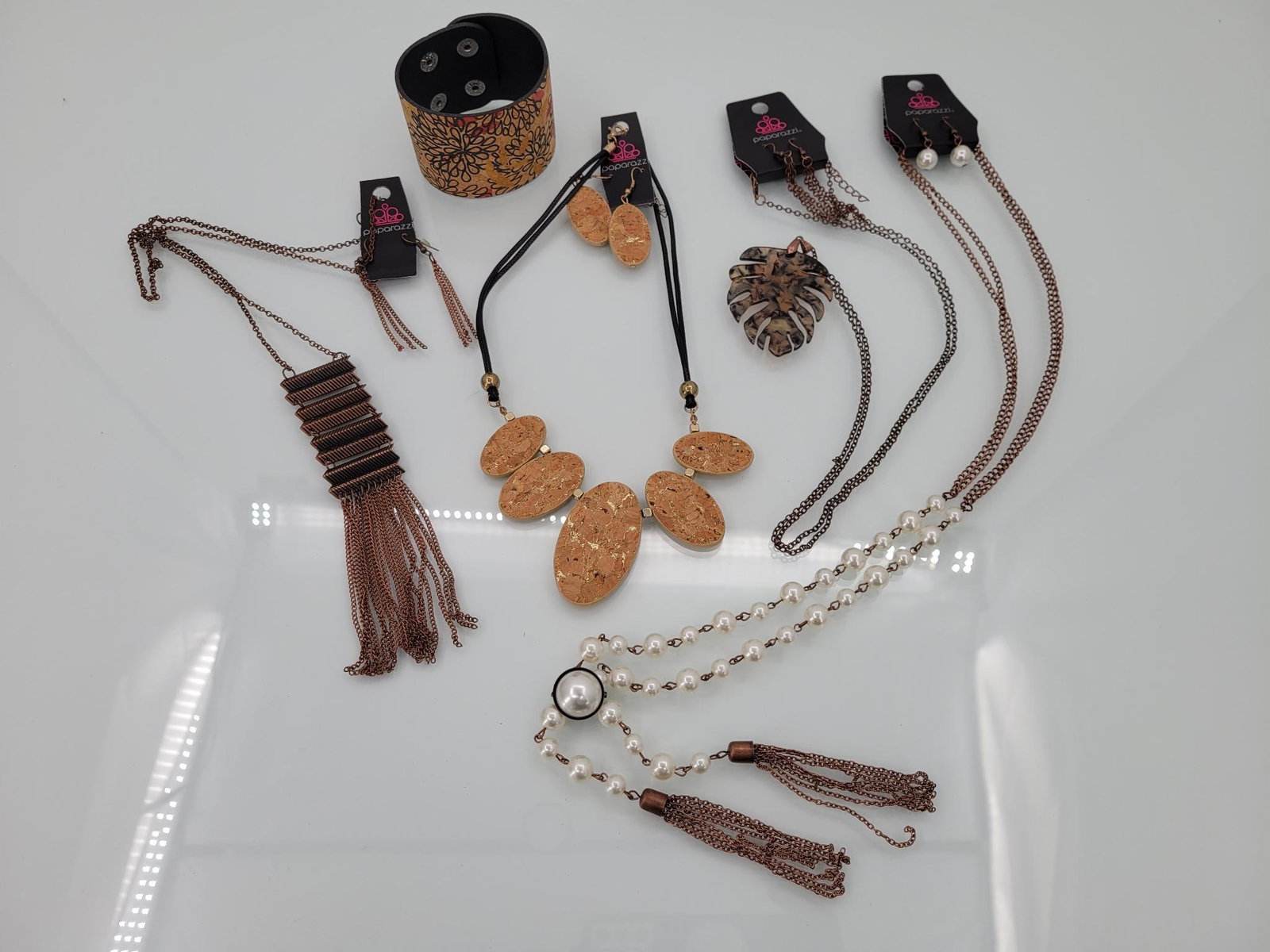 Four Sets Of Assorted Paparazzi Jewelry: Description: four sets of assorted paparazzi jewelry. All four include necklace and earrings new with tags, and one included a cork cuff bracelet
