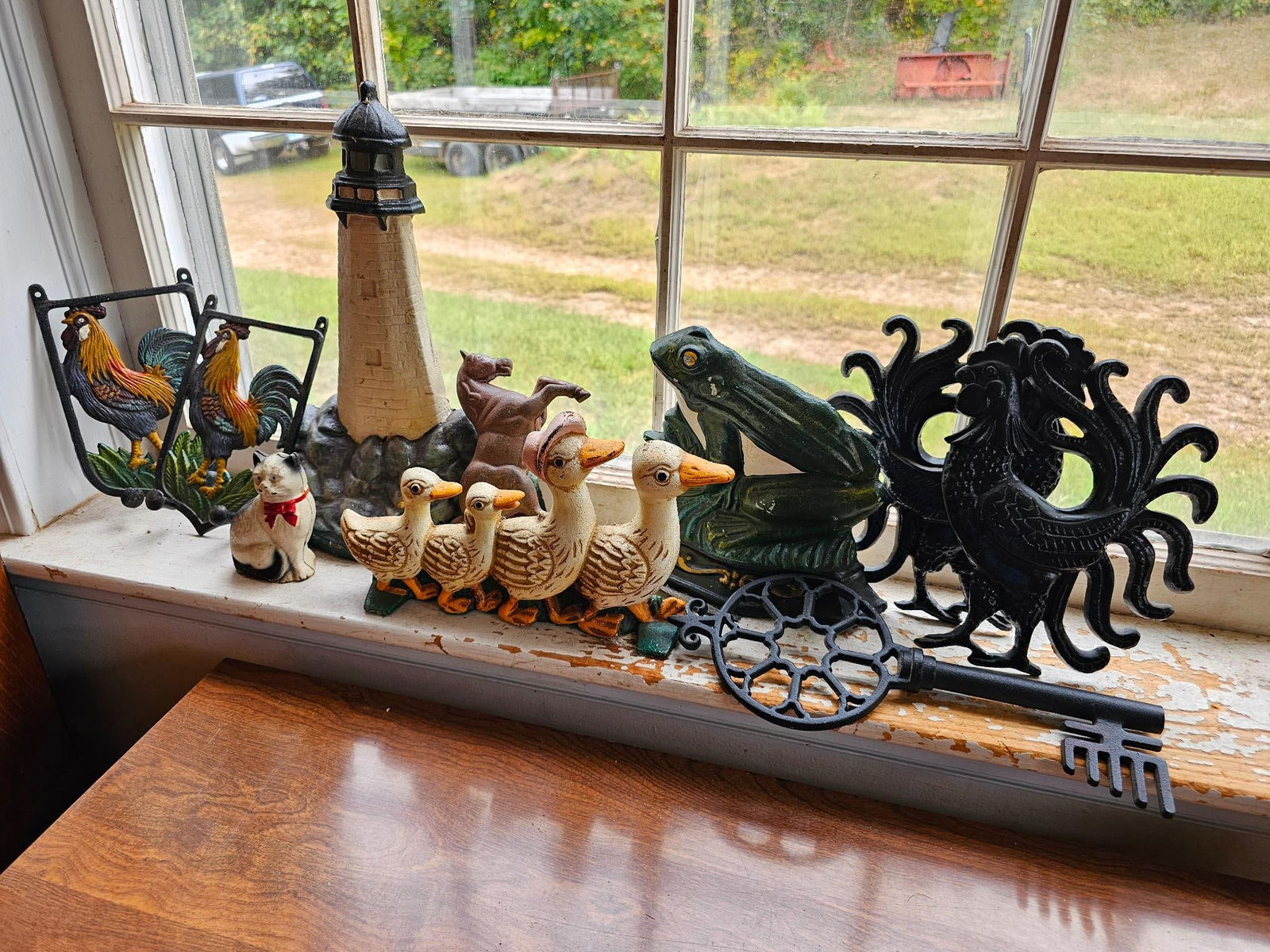 Collection of Cast Iron Doorstops & Figures: Assorted cast iron doorstops & figurines, including roosters, ducks, a lighthouse, and a cat. This lot is offered in estate-found condition. Conditions all appear to be good. Please refer to photos fo