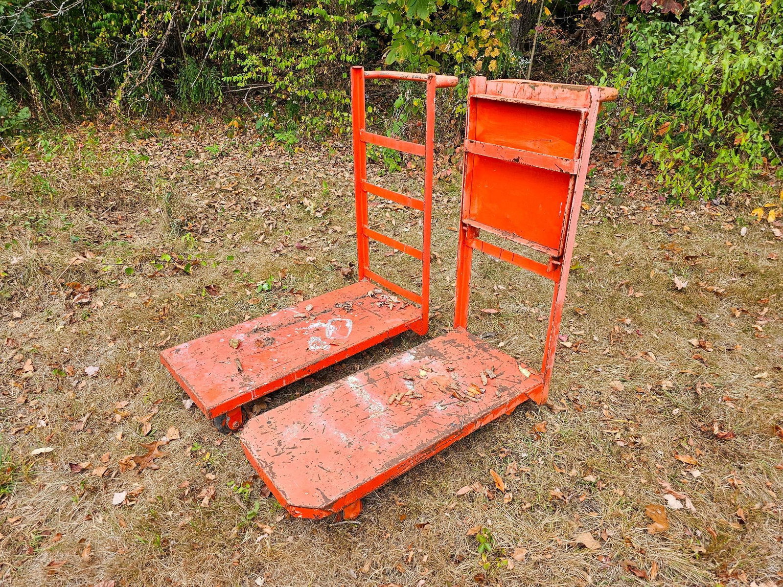 Industrial Warehouse Carts: Pair of red warehouse carts. The carts are offered in estate-found condition, with visible signs of rust, scratches, and wear from use. They are have been and currently are stored outdoors. Please ref