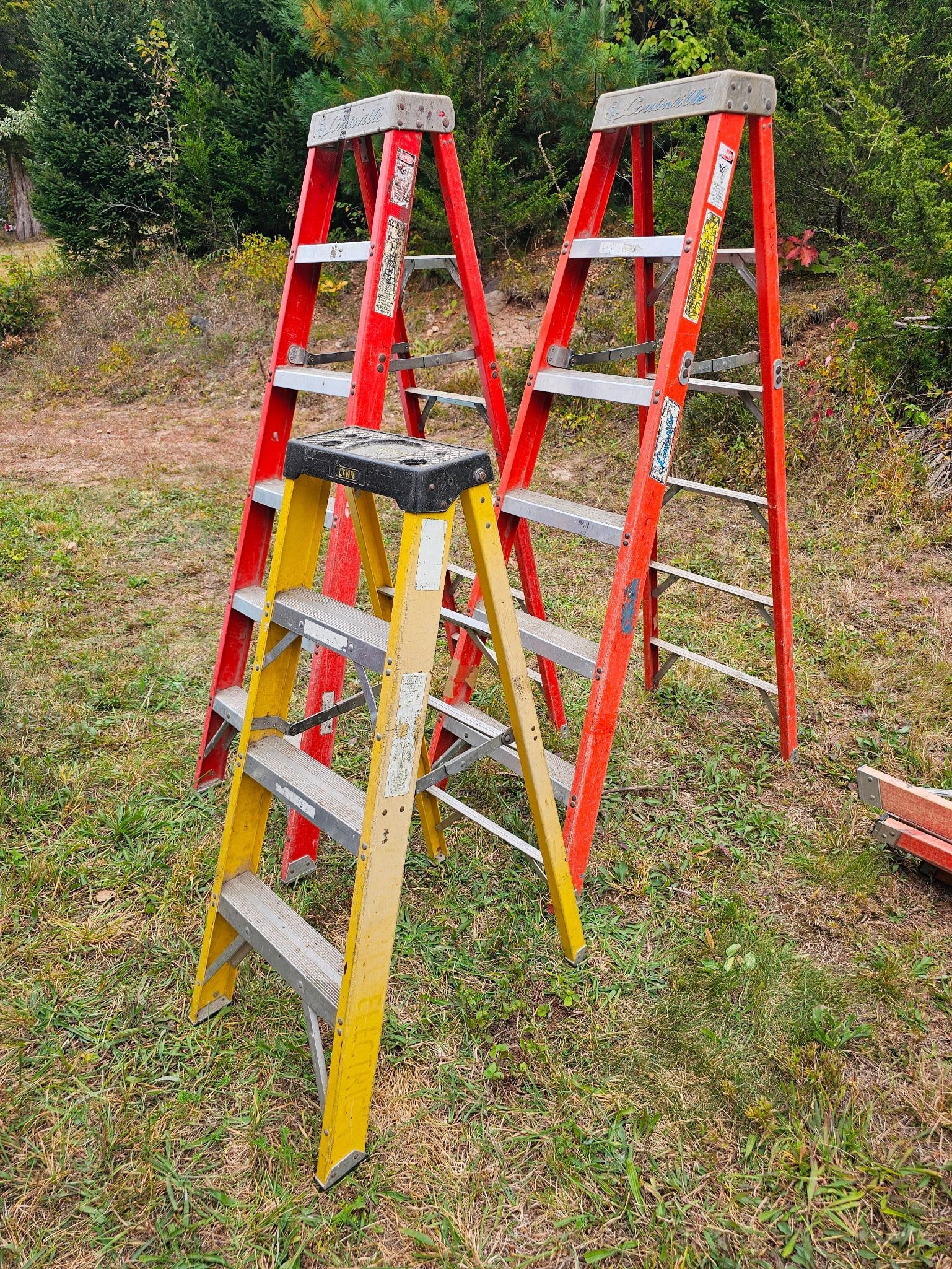 Lot of 3 Louisville Fiberglass Stepladders: lot of 3 fiberglass step ladders, two Louisville 6 ft tall ladders, and a single Lynn 4' ladder. These ladders show expected wear from years of use but remain sturdy. Offered in estate-found condition