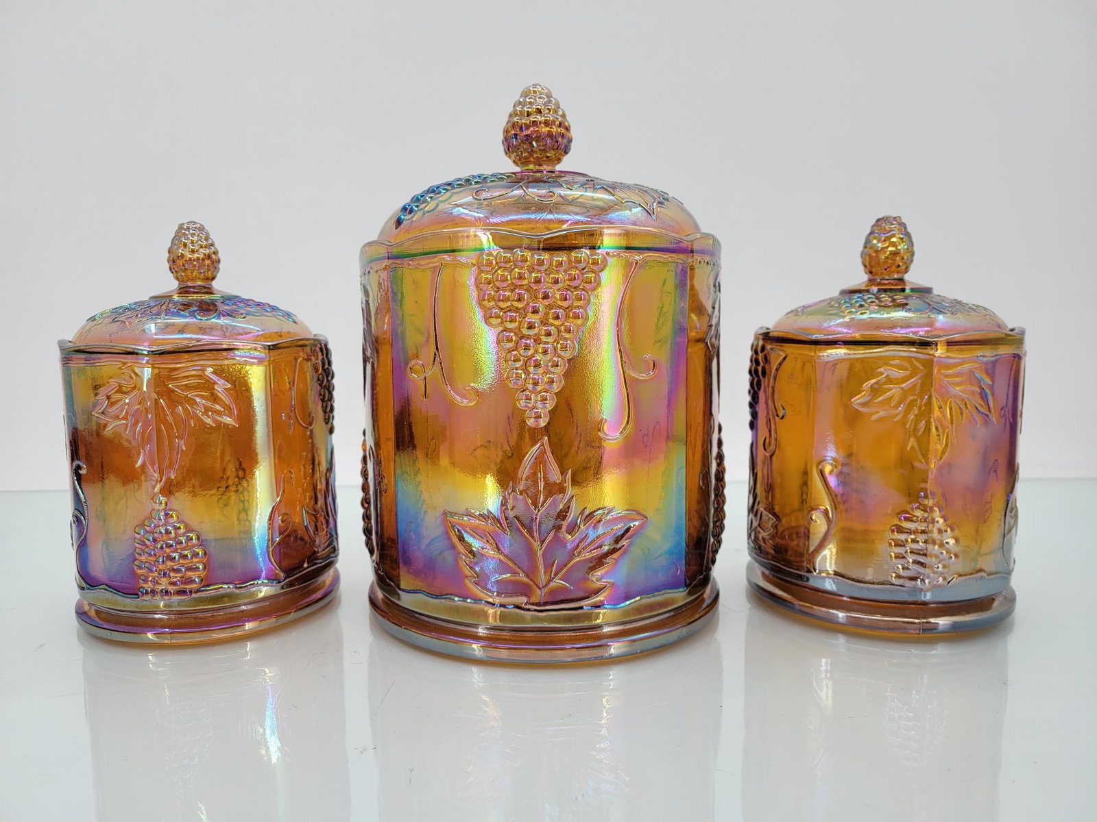 Trio Of Indiana Amber Harvest Grape Canisters: Maker: Indiana Pattern: Amber harvest grape canister Condition Issues (If Any): none Large canister measurements: 6.25 "L x 9.5 "H Small canister measurements : 4.25 "L x 7 "H Condition