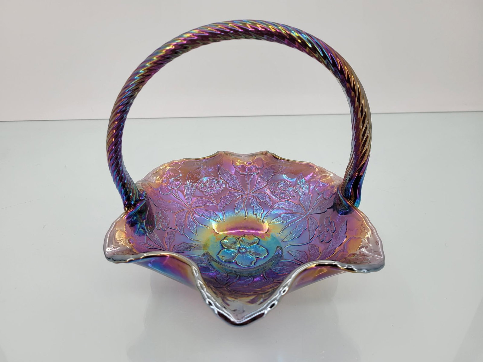 Fenton Iridescent Purple Floral Basket: Maker: Fenton Pattern: Iridescent purple floral pattern Condition Issues (If Any): none Measurements: 7 "L x 8 "W x 7 "H Condition Buyers Premium: 28% For this auction, we&