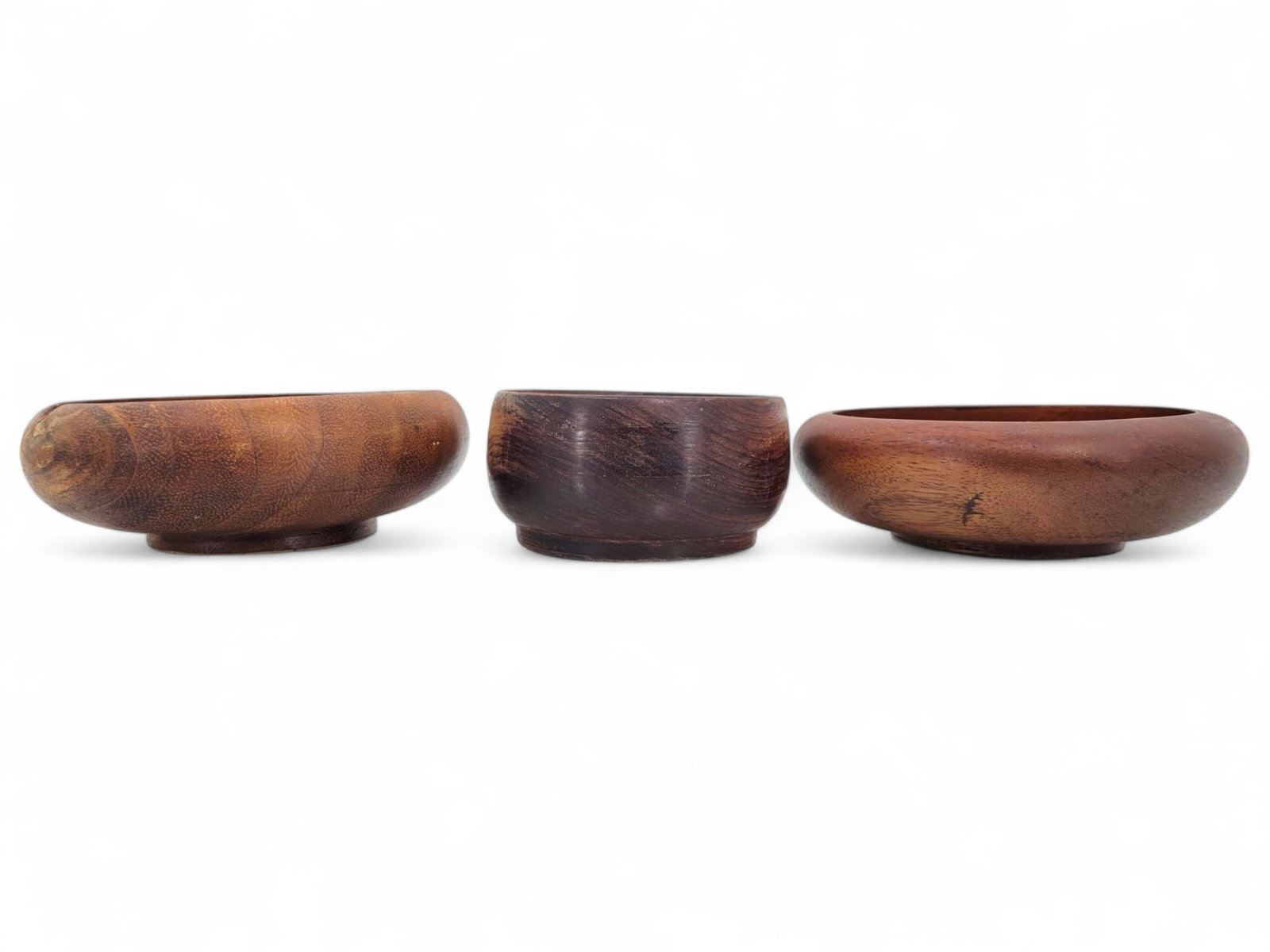Trio of Vintage Wooden Serving Bowls: Three vintage dark-stained wooden bowls with a slightly raised base. Good condition with light wear from age. Measurments: 6.25"W x 2"T
