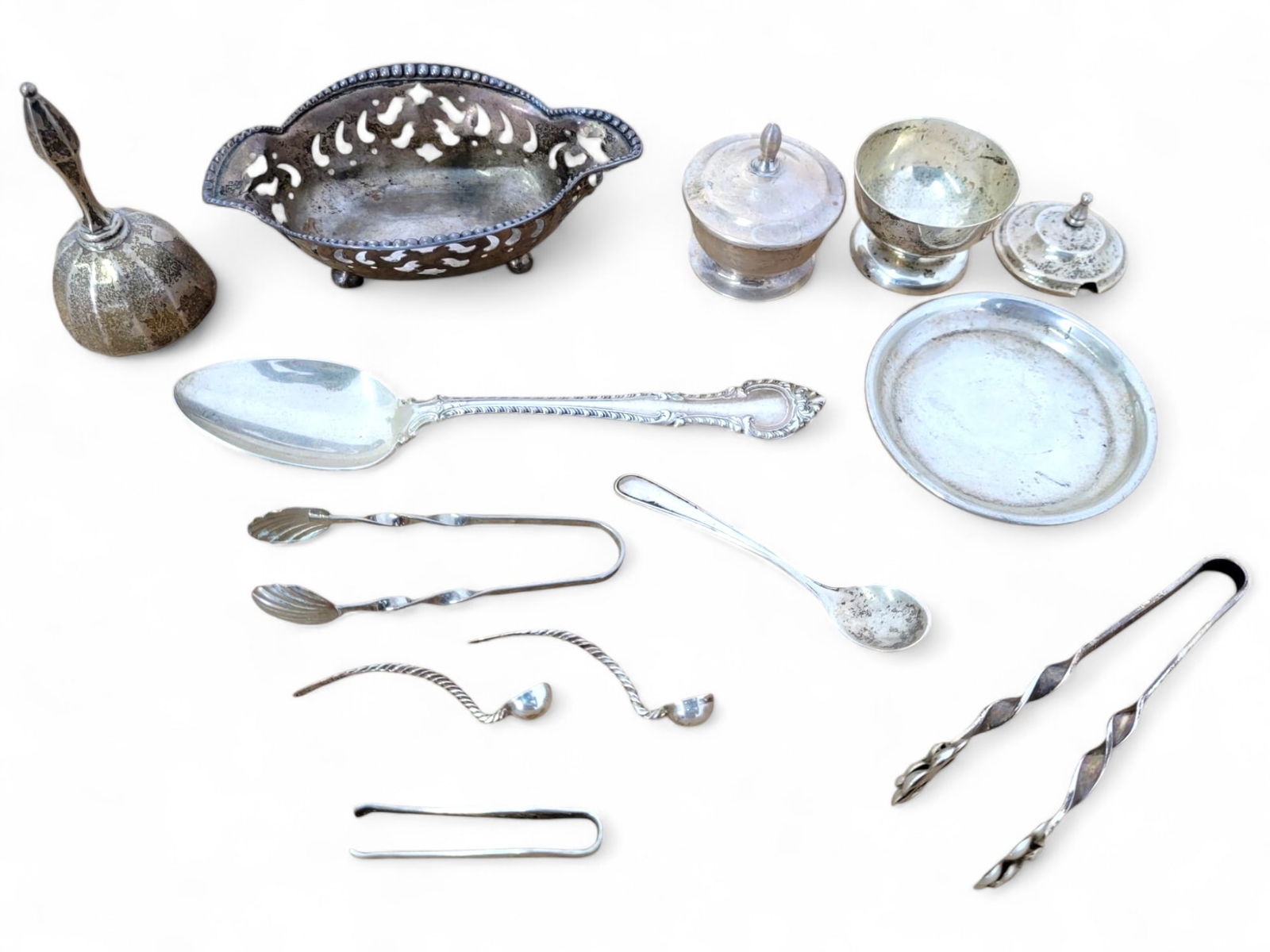 Collection of Sterling Silver Pieces - 6.4 dwt: A collection of sterling silver table accessories, including a sugar bowl, cream pitcher, bell, serving utensils, small sugar tongs, and other small decorative pieces. Items show tarnish and wear cons