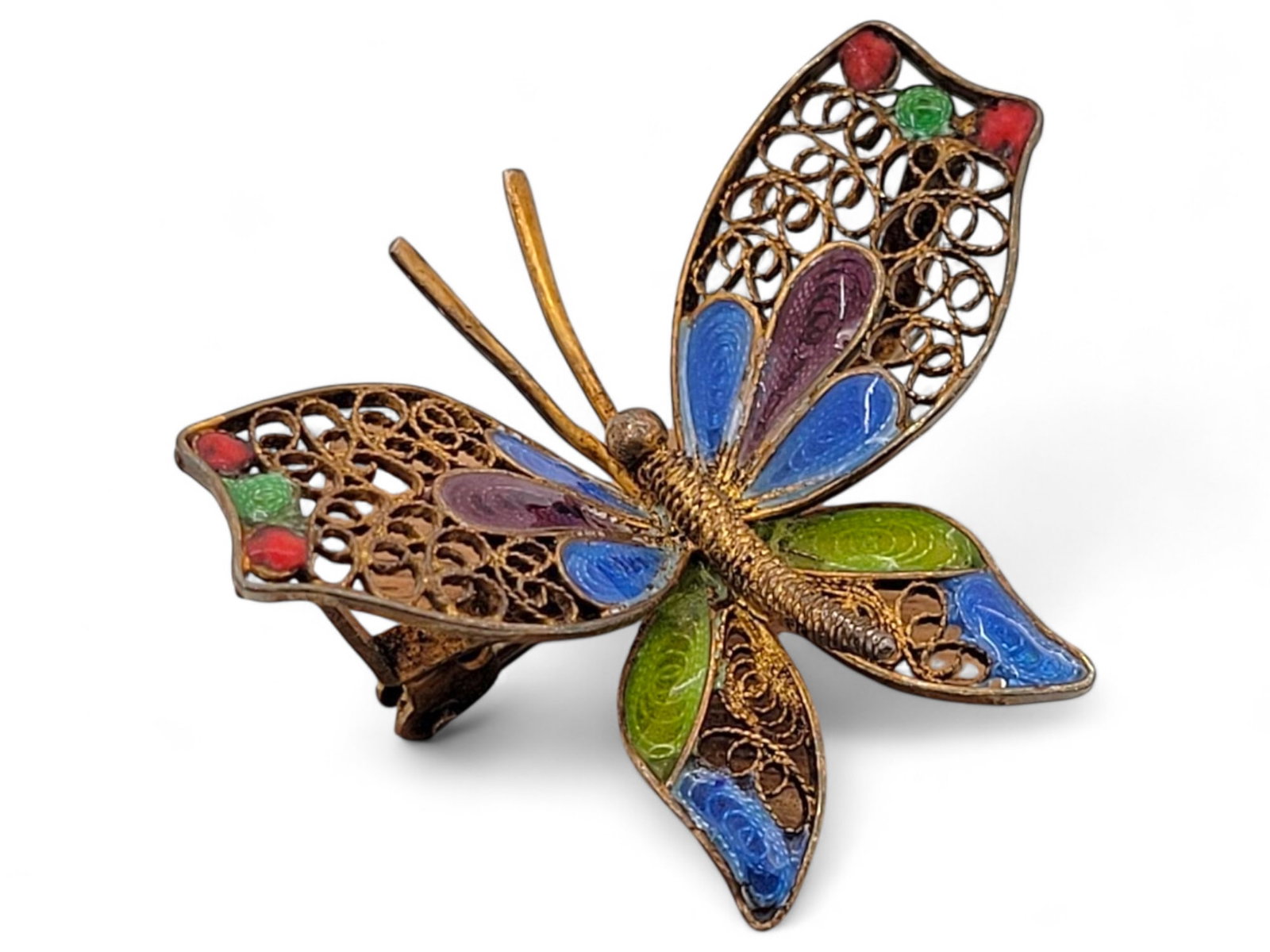 Vintage Enameled Filigree Butterfly Brooch: This vintage .800 silver filigree butterfly brooch features vibrant enamel work in blue, green, red, and gold tones on a delicate filigree base. The brooch is in very good condition with minimal wear.