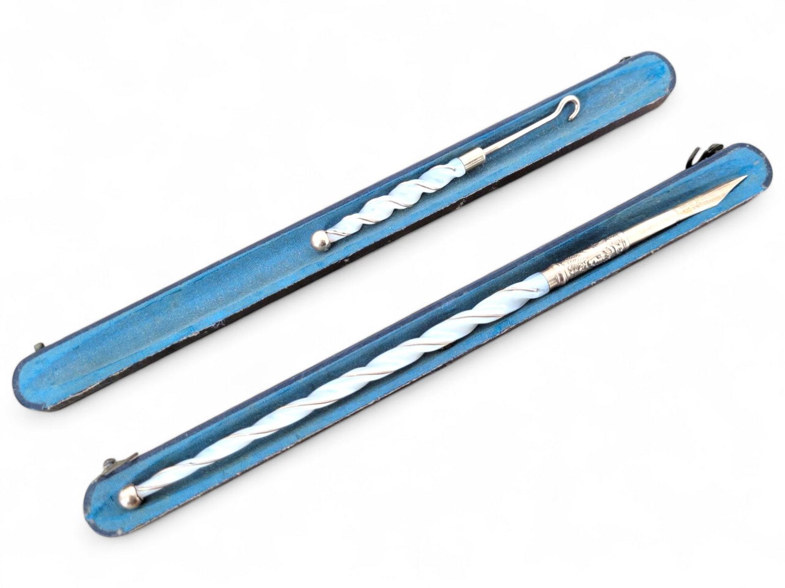 Mother-of-Pearl Crochet Hook and Dip Pen Set: This set includes a carved swirl mother-of-pearl crochet hook and a matching dip pen with a twisted handle design. Both pieces are housed in their original blue case and are in very good condition wit