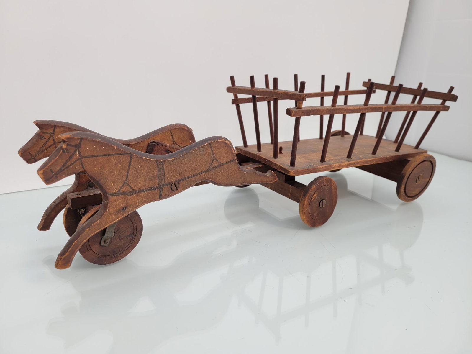 Antique Wooden Childs Pull Toy Horse and Wagon: This lot includes an antique child's pull toy depicting a horse pulling a hay cart. The piece is in fair antique condition, with some ware and repairs to the wood, see lot photos for the con