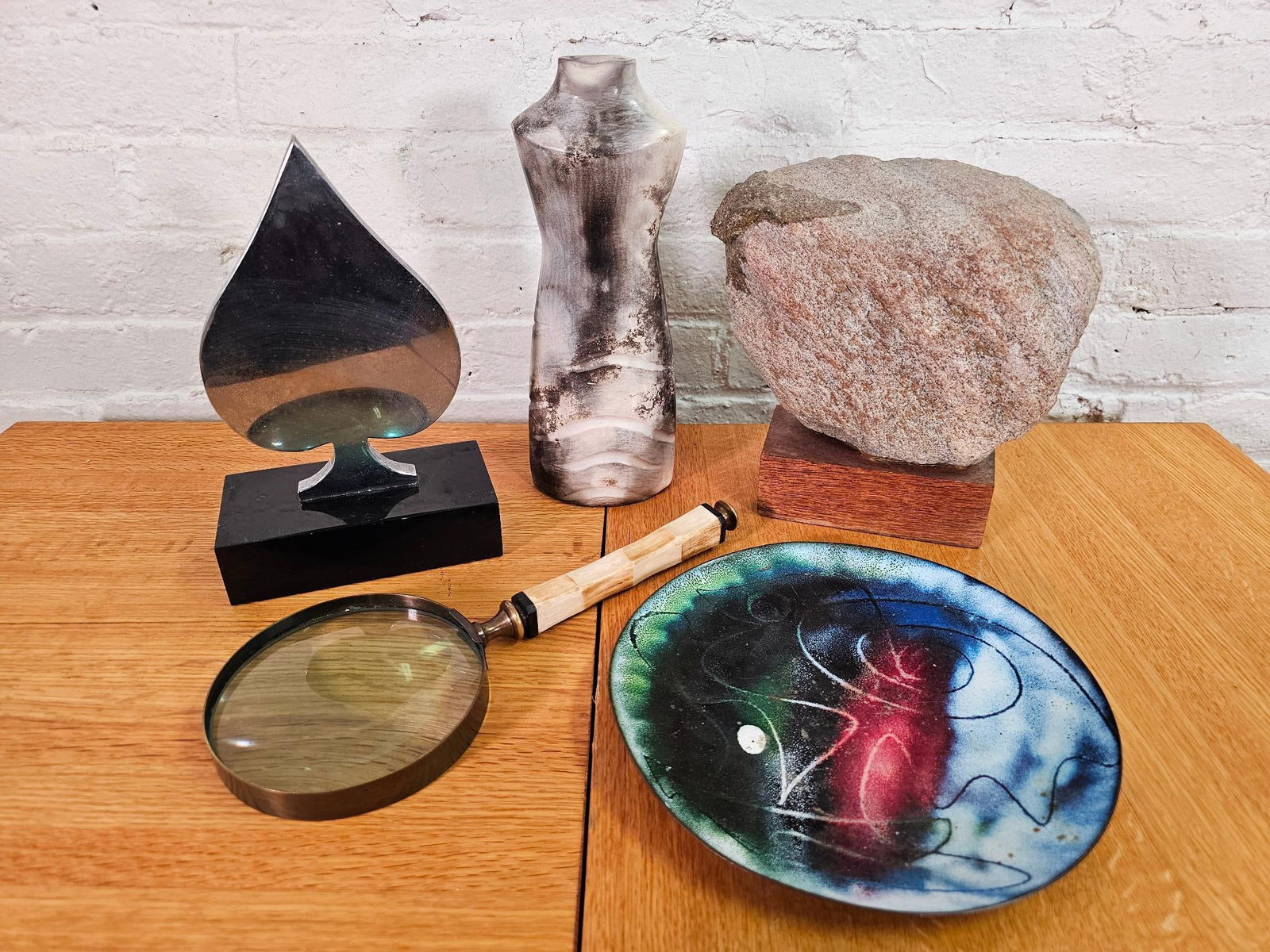 Grouping of Decorative Objects: This lot includes a small grouping of assorted decorative objects to include a vintage enameled copper tray, sculptural metal spade, rock art mounted on wooden base, and a unique magnifying glass.&nbs