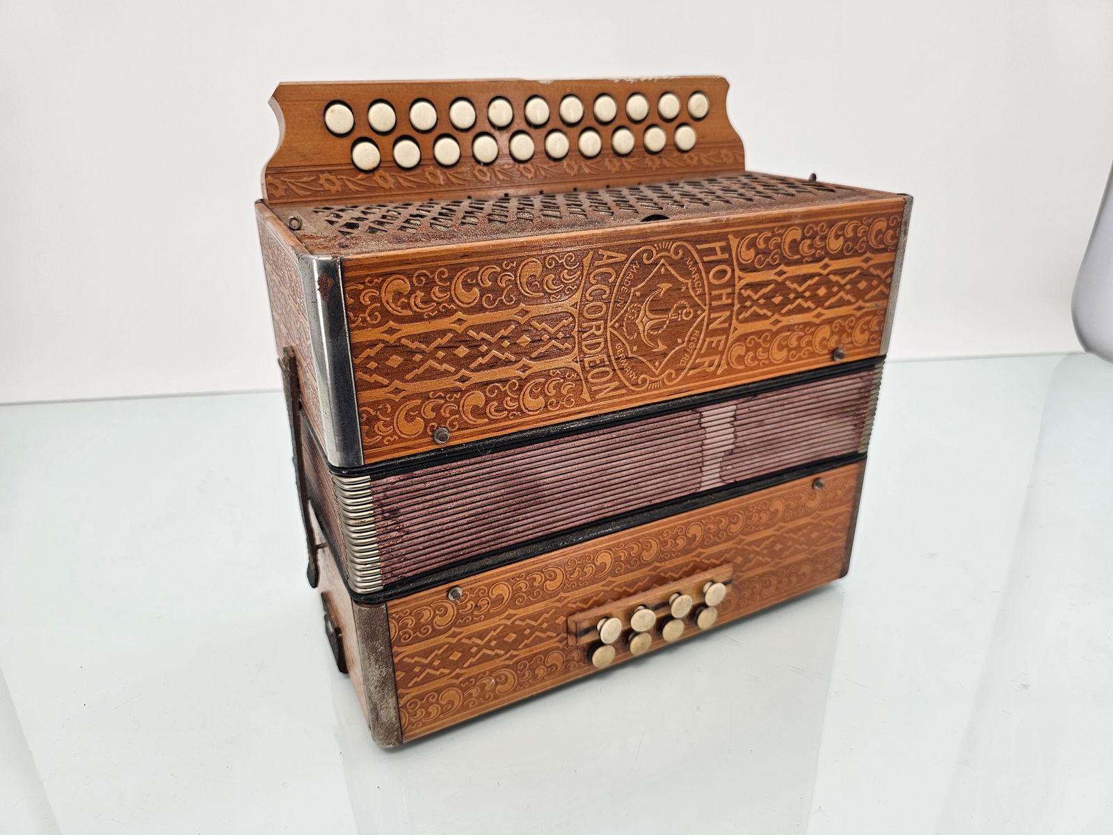Antique Wooden Hohner Button Accordion - Made in Germany: The accordion is in good overall antique condition, with a decorated wooden case. It appears to function based on very limited testing; we did not test each note, only confirmed that it produces sound