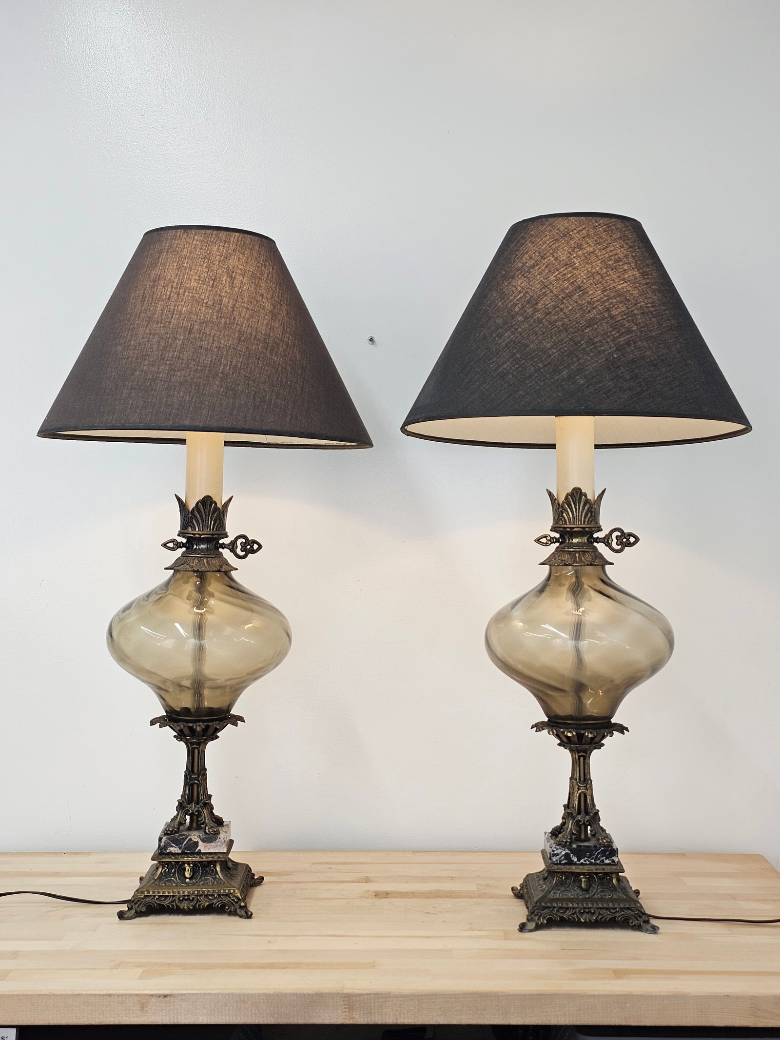 Pair of Vintage Smoked Glass Table Lamps: The pair of lamps is in good vintage condition, each with a smoked glass globe at the base. They are in good working order, see lot photos for more information on the lot and its condition. Measures 3