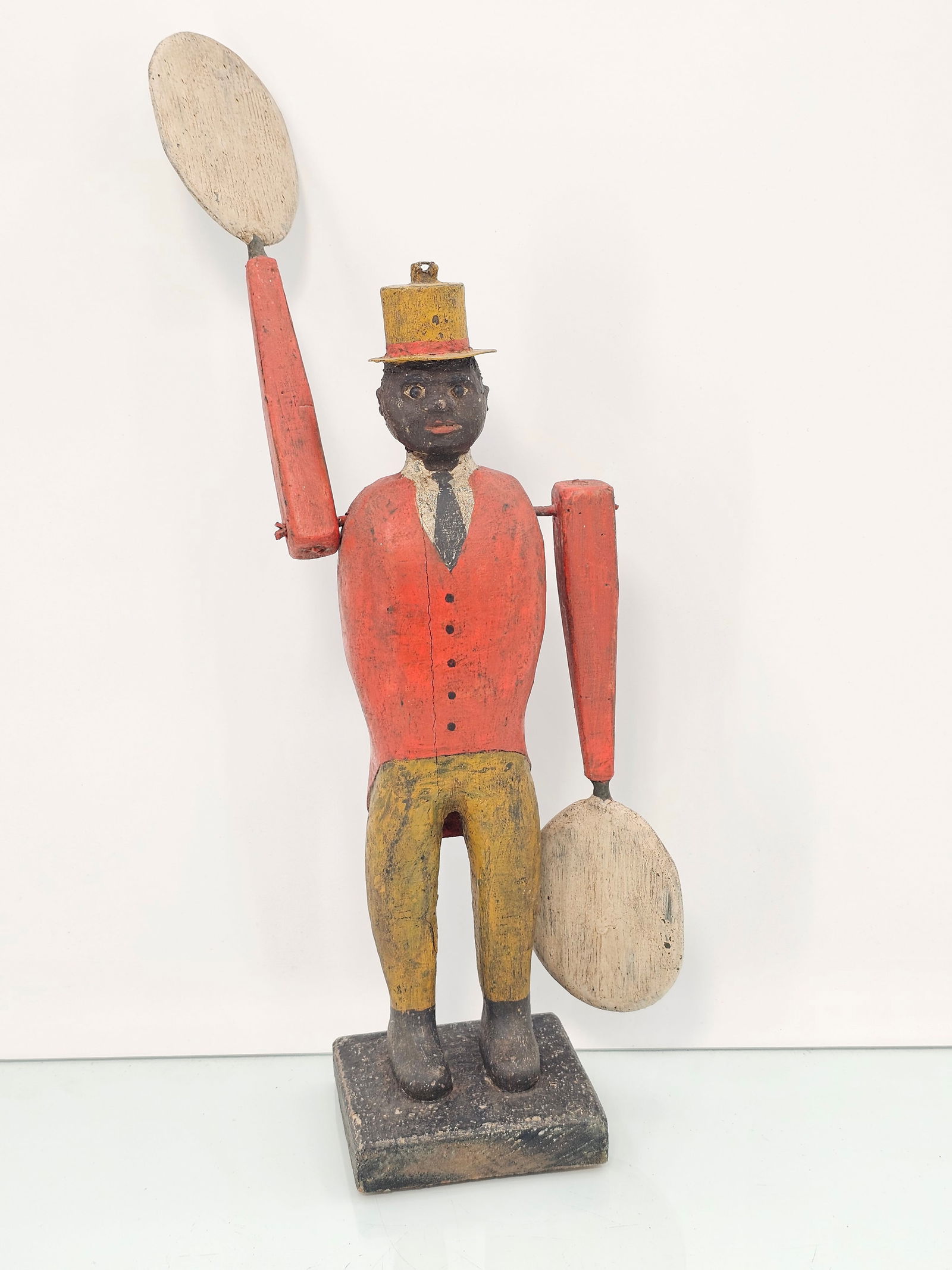 Hand Carved Wooden Folk Art Black Man in Red Suit Whirligig: The piece is hand carved & painted wood appearing to be vintage / antique in age. Showing a figure of a black man in a red suit, the hands spin in the wind, one is a little loose. See lot photos for m