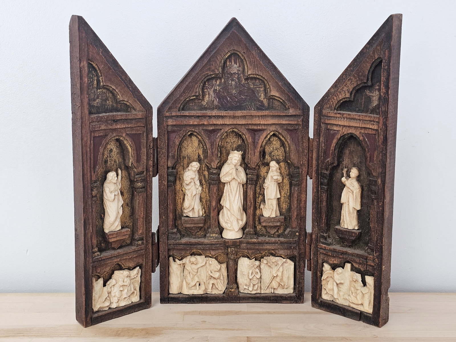 Antique 19th C. Italian School, Carved Bone Triptych of Madonna & Saints: The piece appears to date to the early 19th century, in the style of the Italian schools of the period. It features carved bone scenes of the Madonna and saints set into a well-aged wooden background.