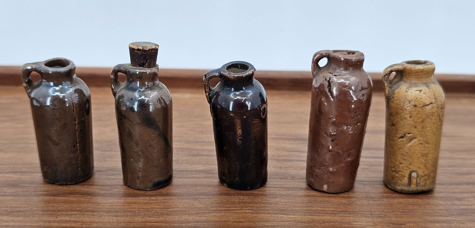 Lot of 19th Century American Clay Terracotta Miniature Bottles - 1.75"T: This lot includes a grouping of very small miniature terracotta bottles, each standing only 1.75" tall. The pieces retain there original finish with no major damage or flaws beyond some expected age c