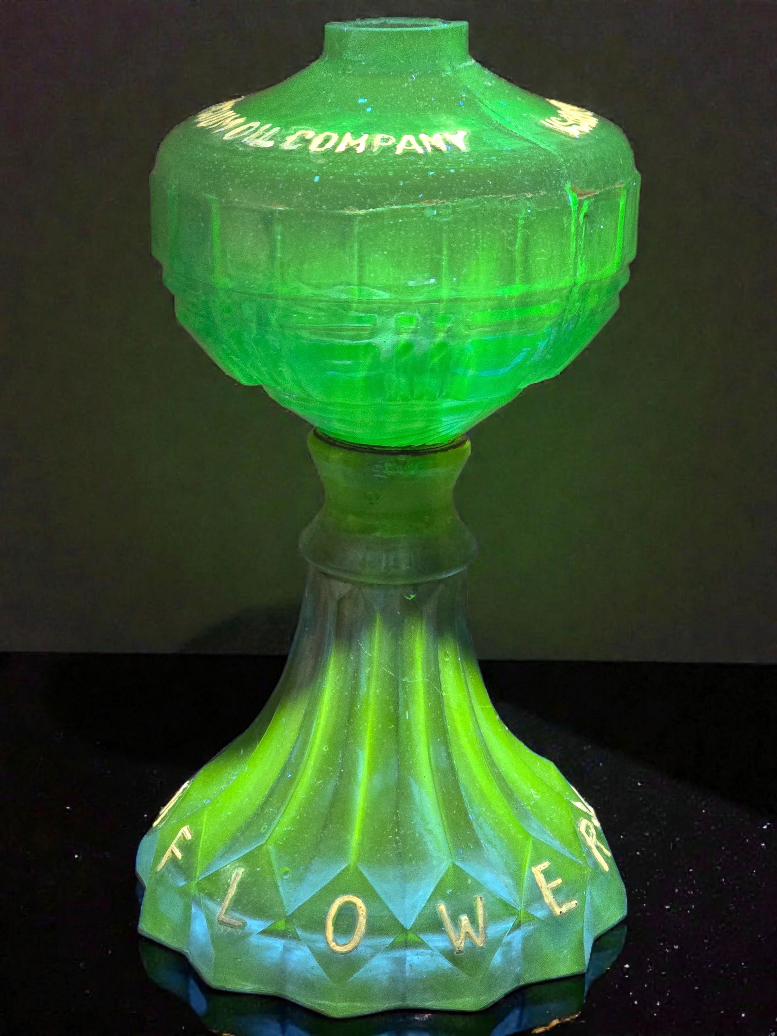 Early Pressed Glass "Vacuum Oil Company" Blue Uranium Glass Oil Lamp: This lamp is a unique advertising piece from the Vacuum Oil Company promoting their Sunflower Seed Oil. The lamp is made of pressed blue uranium glass and is reactive to UV light. Embossed on the lamp