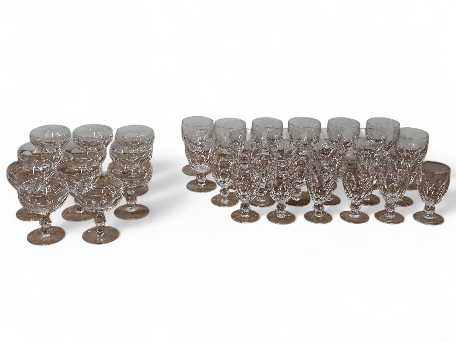 Large Grouping of Waterford Crystal Kathleen Pattern Glasses: This lot includes an assortment of Waterford crystal Kathleen pattern cut glass stemware. Types of glasses include: water goblets, claret wine goblets, small champagne/sherbet glasses, and large champ