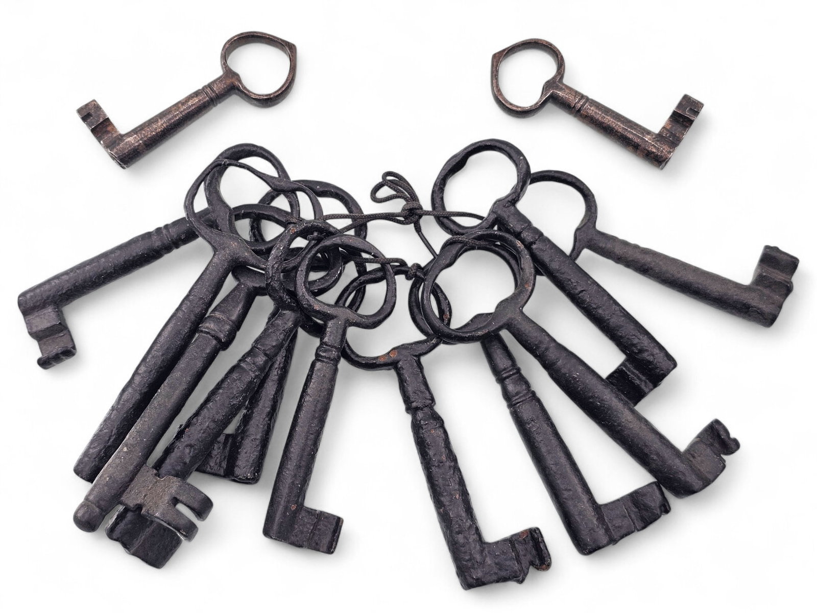 Grouping of Antique Cast Iron & Brass Skeleton Keys: This lot includes an assortment of antique skeleton keys, most of them cast iron and some brass. They are of various sizes and styles. Heavy oxidation and discoloration along with wear consistent with