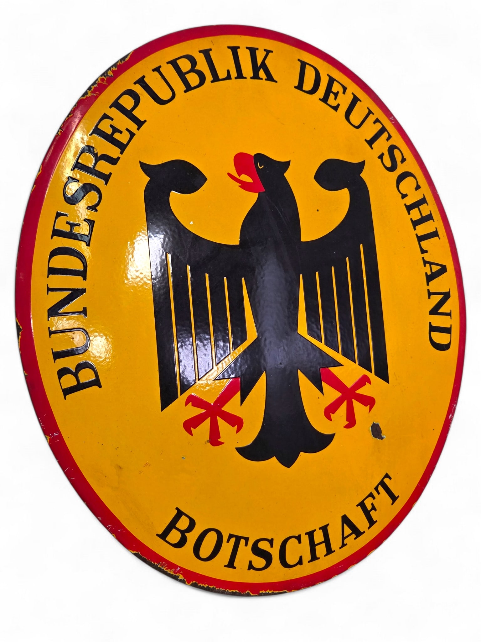 Federal Republic of Germany Embassy Porcelain Sign - 28" L: Single sided porcelain enamel German embassy oval concave sign. The sign reads “Bundesrepublik Deutschland - Botschaft,” which translates to "Federal Republic of Germany - Embassy." The sign f