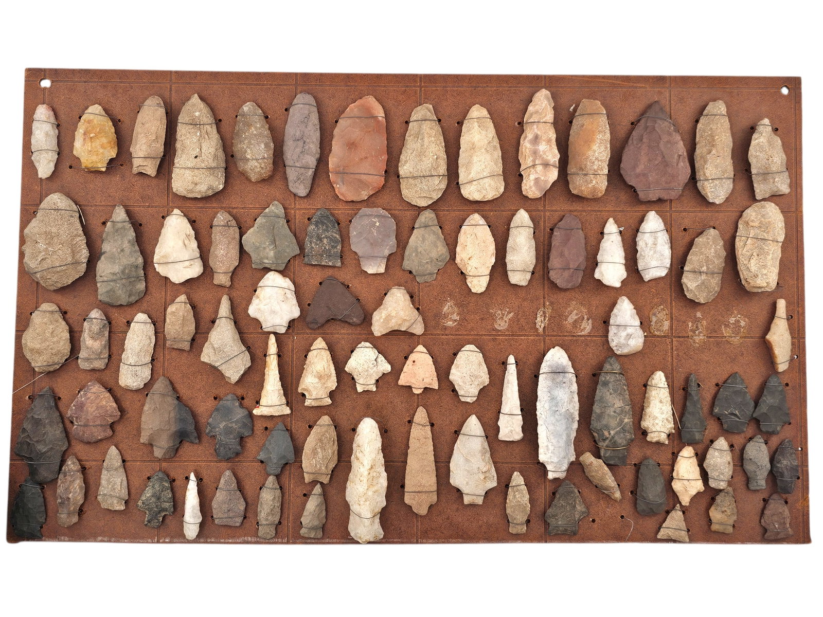 Grouping of Early Stone Arrowheads & Spearheads On Display Board - 15 x 24: Grouping of Early Native American stone arrowheads and a couple of small Spearheads displayed on board. Many with straight stems and bifurcated ends. See photos for more details on the contents of thi