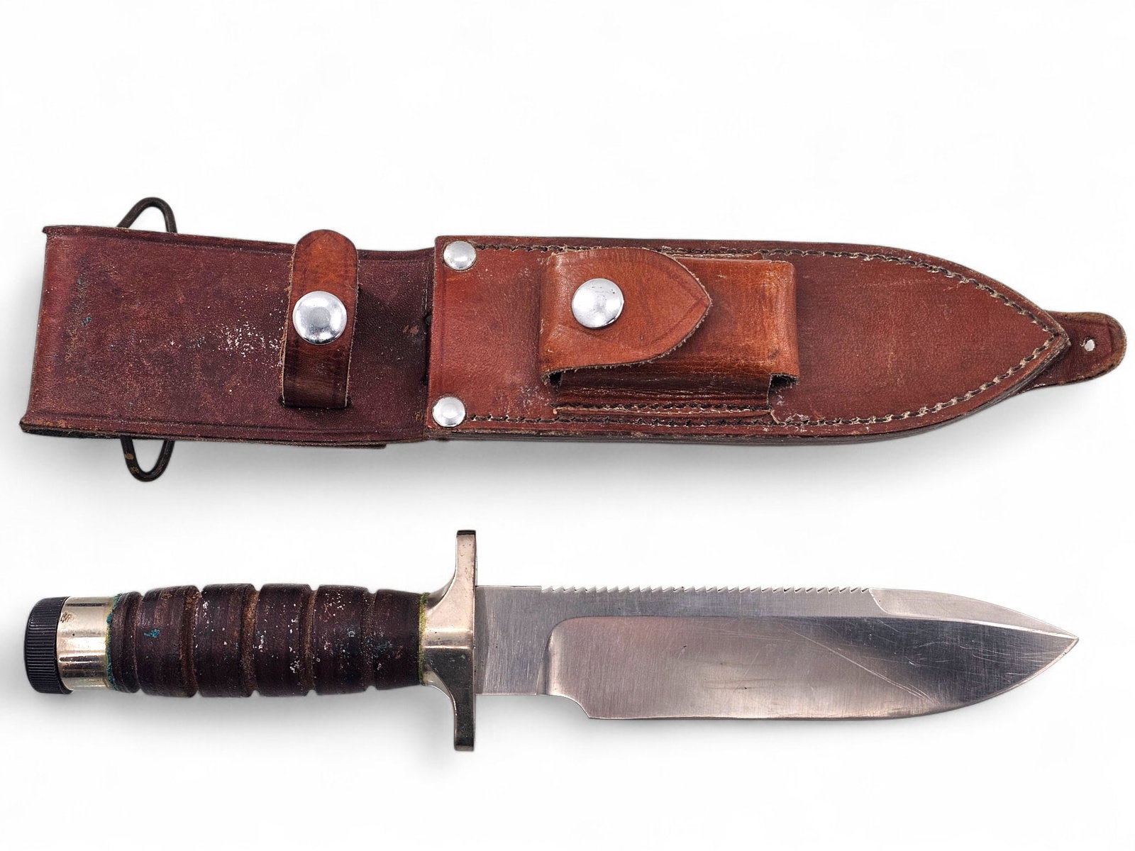 Vietnam Era Hackman Finland Survival Knife: Vietnam era Hackman Finland Survival Knife with drop point blade and serrated spine. Brown leather sheath with sharpening stone and matches in small compartment, Plastic end cap reads "Pedro Domenico