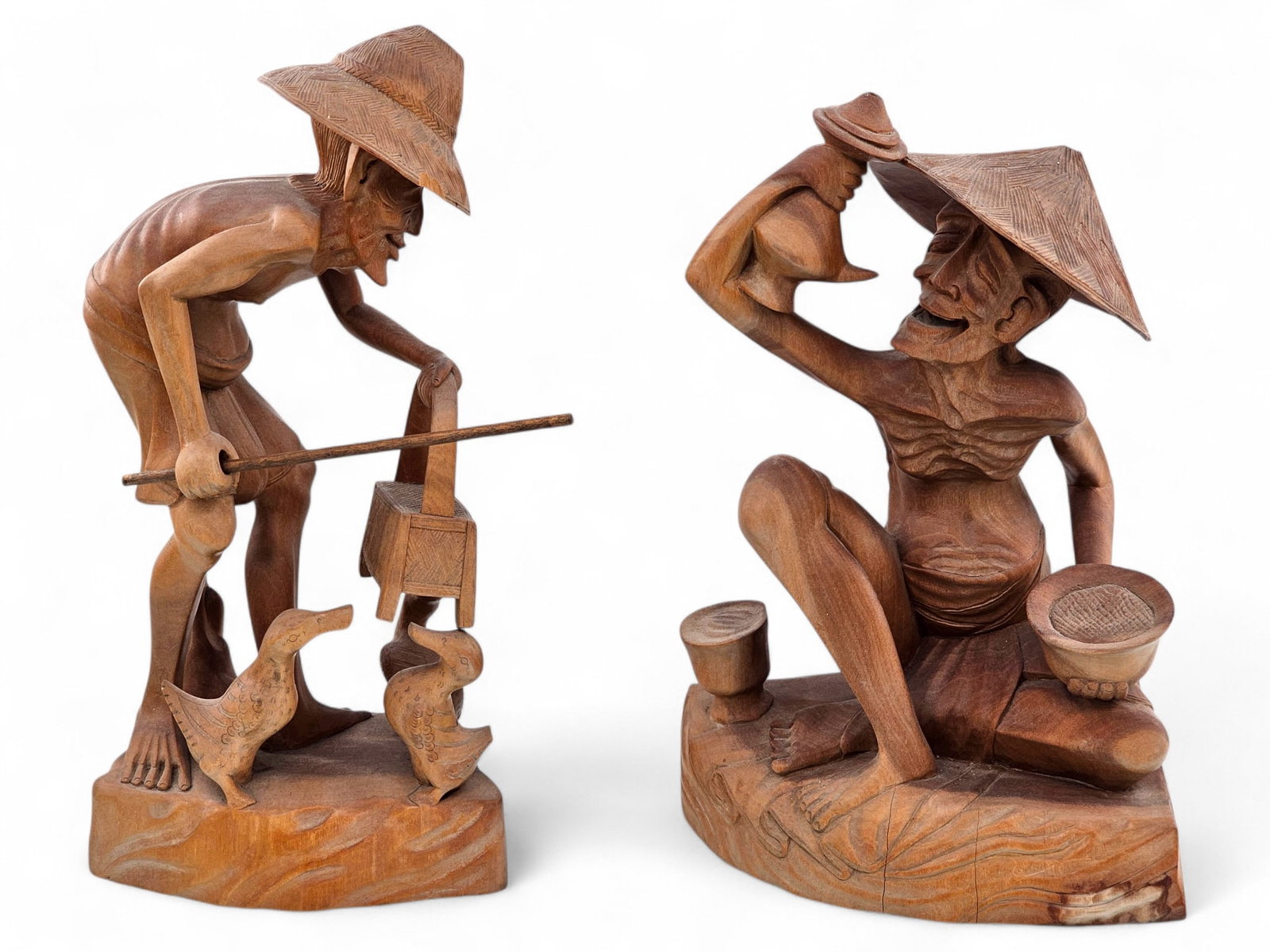 Pair of Oriental Carved Wood Fisherman Figurines: This lot includes two hand carved wood Oriental folk art figurines/sculptures.Each sculpture depicts an older man, fishing or harvesting. Some surface wear and checking consistent with age. See photos