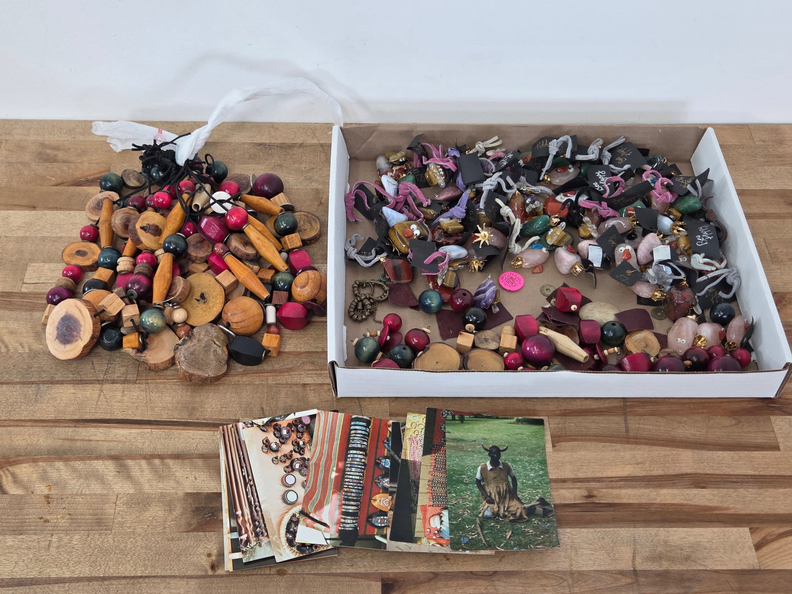 Grouping of African Handcrafted Earrings, Decorations, & More: This lot includes a variety of handcrafted African items such as painted wood earrings, hard stone bee and insect trinkets, and other assorted items. Wear consistent with age with no notable damages v
