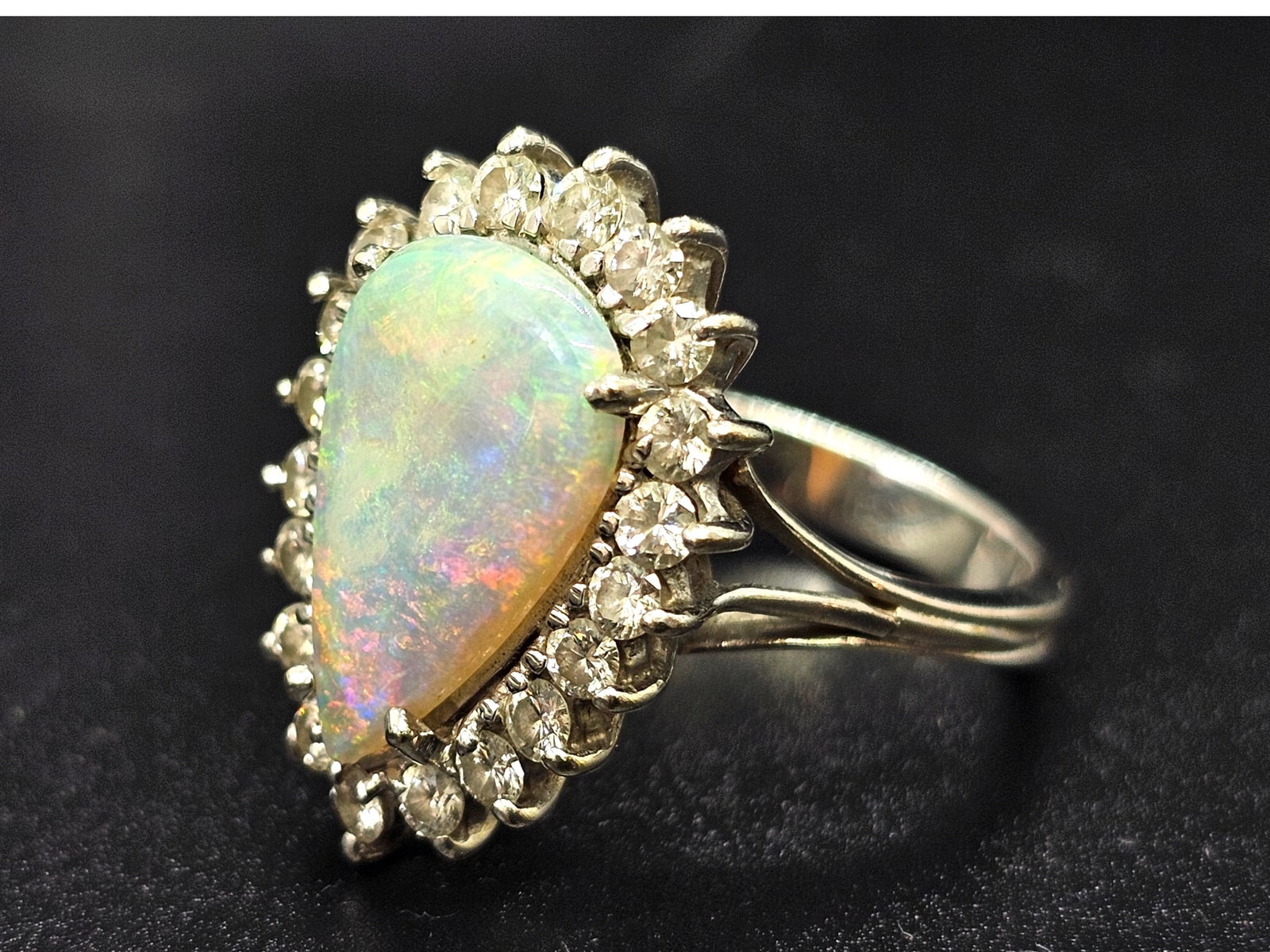 Fine 18k White Gold Teardrop Opal with Diamond Halo Surround Ring: Details: The ring features a large teardrop cut opal, surrounded by twenty (20) small cut diamonds. All set into 18k white gold Material: 18K White GoldBrand/Designer: Unknown / Unm