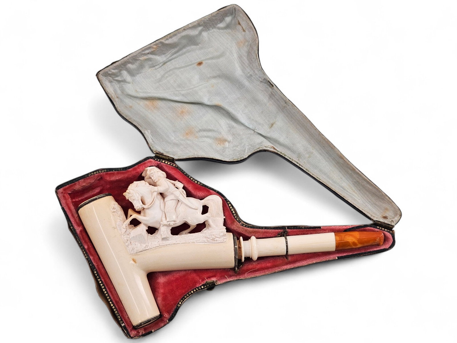 Meerschaum Pipe with Soldier on Horse: Carved meerschaum tobacco smoking pipe with a carved soldier figure atom a horse. Stem is white with amber toned end and attached to head with small chain. The pipe comes in a fitted case. Wear consis