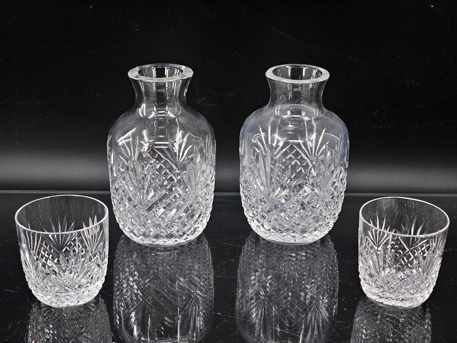 Pair of Cut Crystal Bedside Carafes with Tumblers: This lot includes two cut crystal bedside water carafe & tumblers. They feature geometric cut designs in clear crystal glass. They appear to be unmarked/unsigned. The glasses appears to be in good con