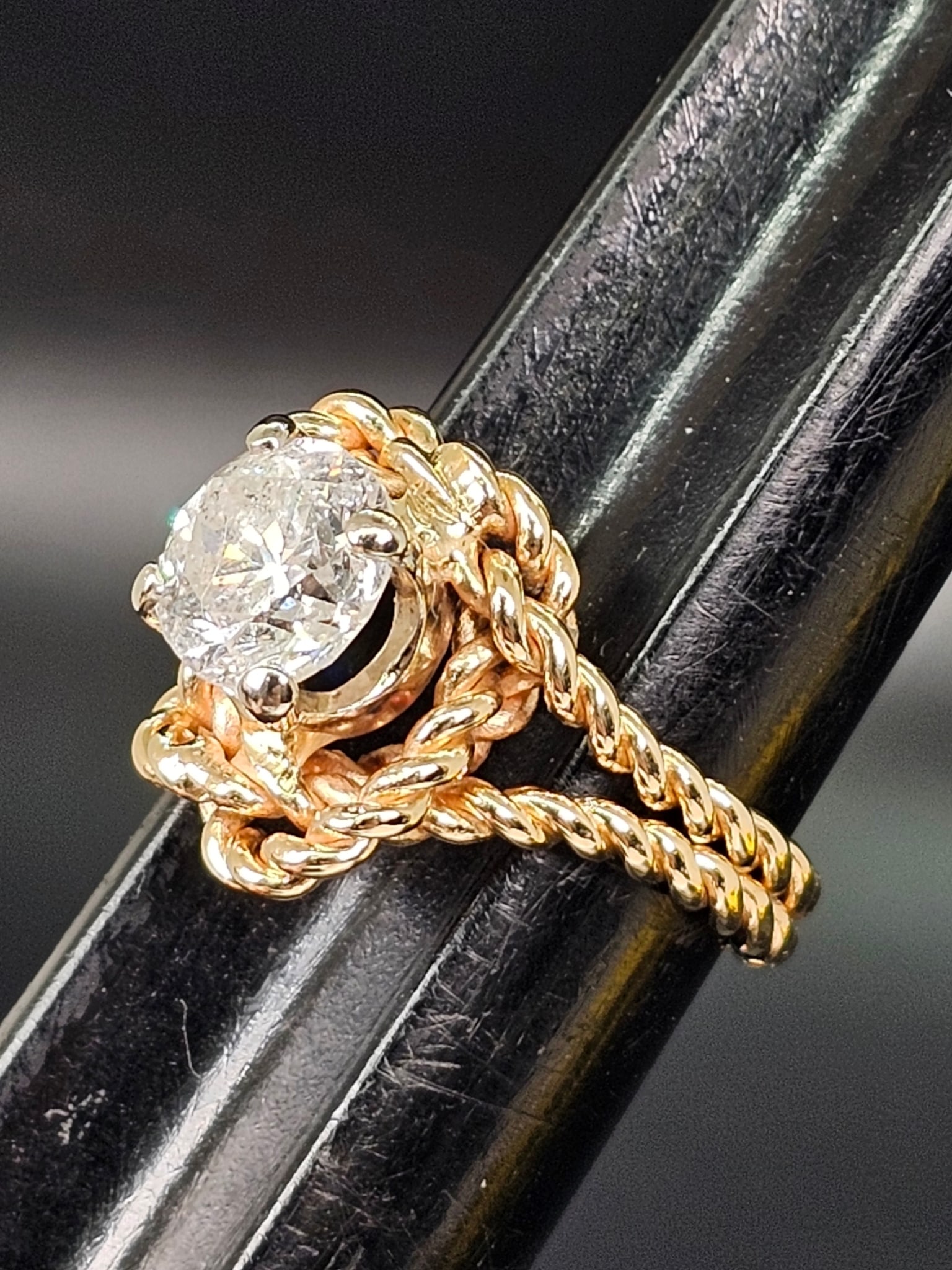 Vintage 1.44 CT Brilliant Cut Diamond Ring in 14K Yellow Gold Rope Design: Details: This ring features a round brilliant cut diamond secured in a four-prong setting. The mounting displays an intertwined rope style design forming a double band appearance around the center sto