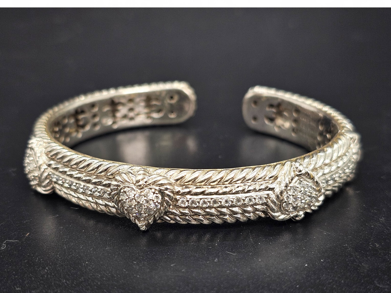 Signed Judith Ripka Sterling Silver & CZ Bangle Bracelet: Details: The bracelet features a twisted rope design with CZ hearts throughout. Material: .925 Sterling Silver & Cubic ZirconiaBrand/Designer: Judith RipkaCondition: Very good