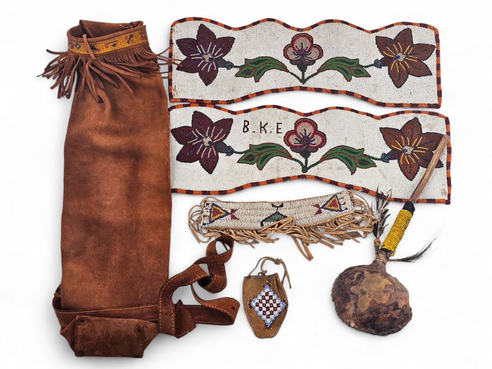 Grouping of Native American Beaded Ceremonial Articles & More: This lot includes a variety of Native . American items, many with beadwork. Some items include: a leather pouch with beaded accents, a pair of beaded sashes, and a Ceremonial rattle. Wear consistent w