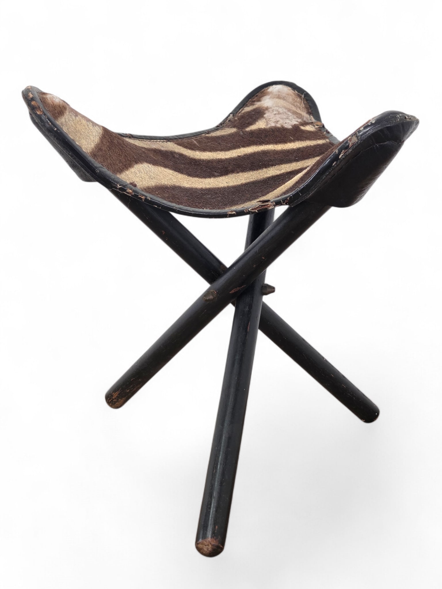 Genuine Zebra Skin African Folding Camp Stool - 1960s: Campaign stool with genuine Zebra Skin seat, likely mid century, Triangular leather seats with zebra hide and ebonized wood tripod base. Wear and scratching to legs, along with notable cracking and te