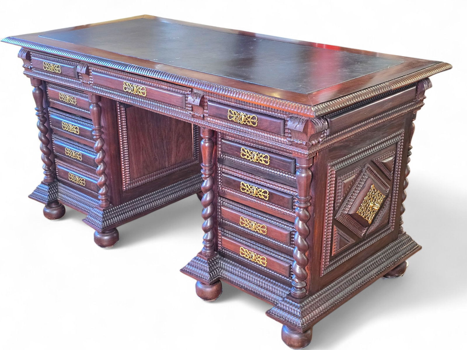 Portuguese Baroque Style Carved Walnut Kneehole Desk:  Portuguese baroque style carved walnut kneehole desk. Diamond shaped cushion paneled cabinets with ripple moulded carved borders and brass fittings.Ornately carved trim and ball feet. The top o