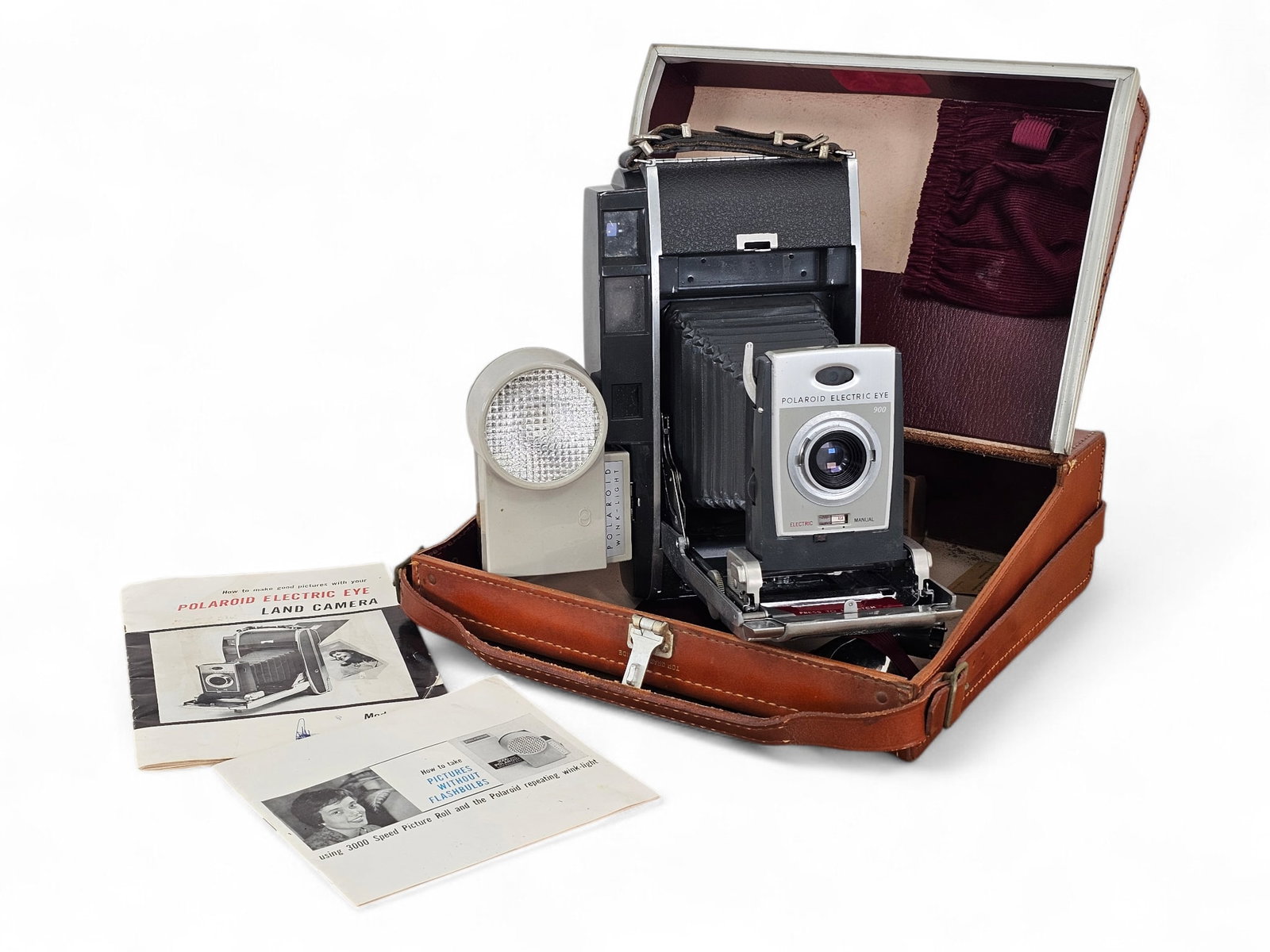 Polaroid 900 Electric Eye Land Camera w/ Case: Polaroid Electric Eye Land Camera Model 900 in original leather case. The lot also includes a paper manual and other accessories. Camera is not guaranteed to function. See photos for more item and con