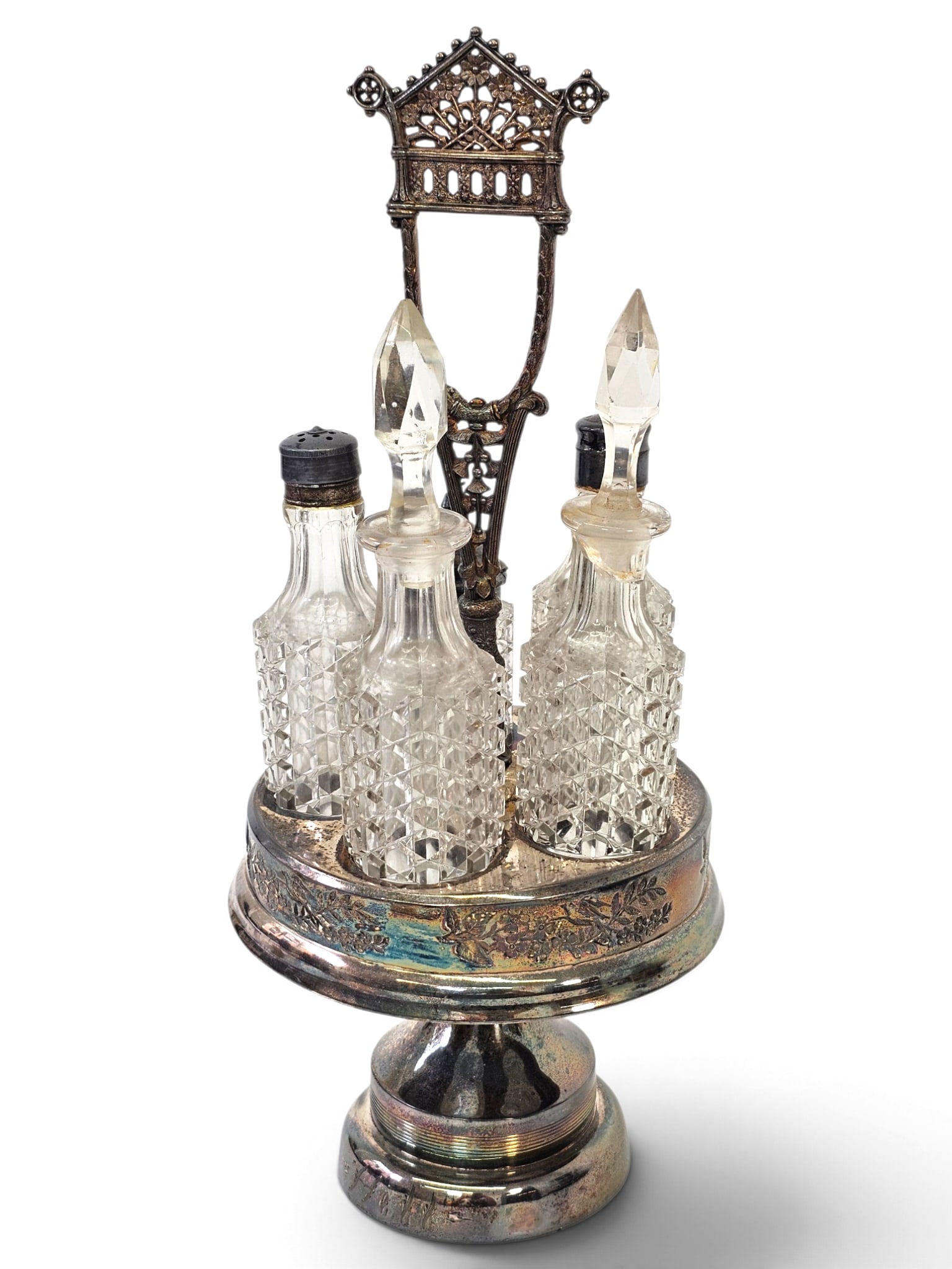Victorian Gothic 5-Bottle Silver-Plate Cruet Set: An antique late 19th-century Victorian Gothic Revival silver-plated revolving caster/cruet stand set. Features a central pierced architectural handle with Gothic tracery above a rotating circular gall
