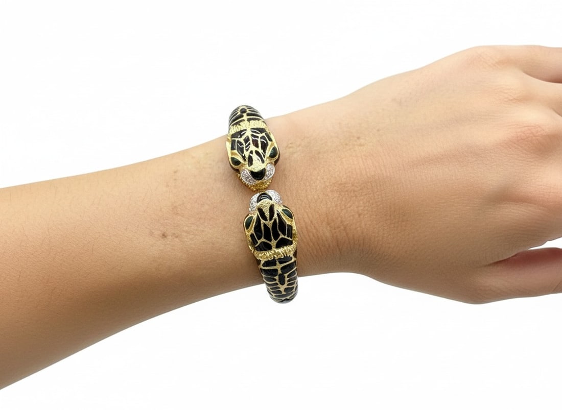 FRASCAROLO 18K Yellow Gold Panther Diamond & Enamel Bangle: Bold 18K yellow gold bangle by the renowned jewelry house Frascarolo, featuring twin panther heads adorned with lustrous black enamel and set with 20 sparkling F-G color, VVS-VS clarity diamonds total