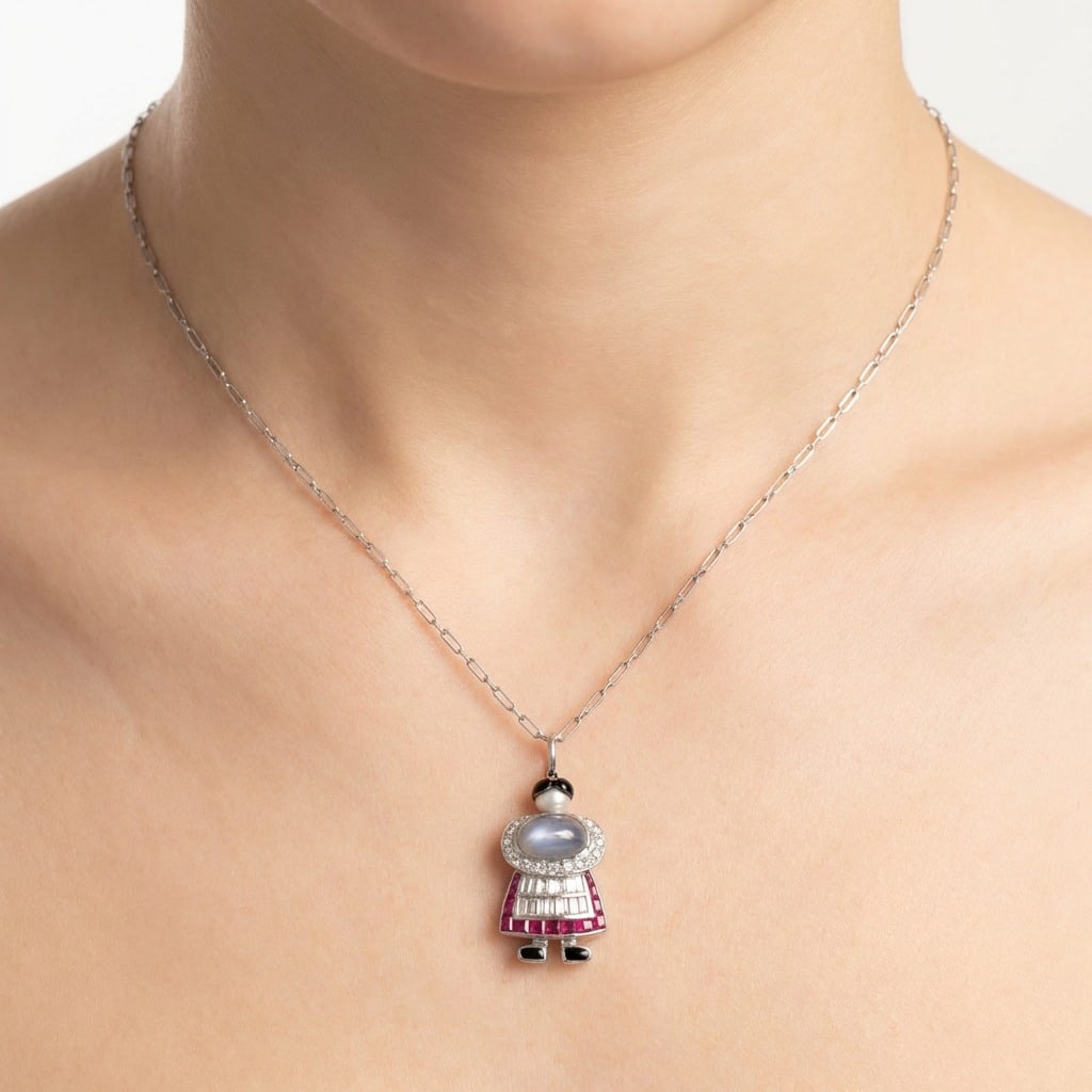 Art Deco Platinum Natural Pearl, Diamond, Star Sapphire, and Burma Ruby Pendant & Chain: Art Deco platinum pendant—a whimsical figural design featuring a luminous approx. 2.00 ct star sapphire cabochon as the head, a skirt of 13 Burma rubies totaling approx. 0.70 ct, baguette diamond ac