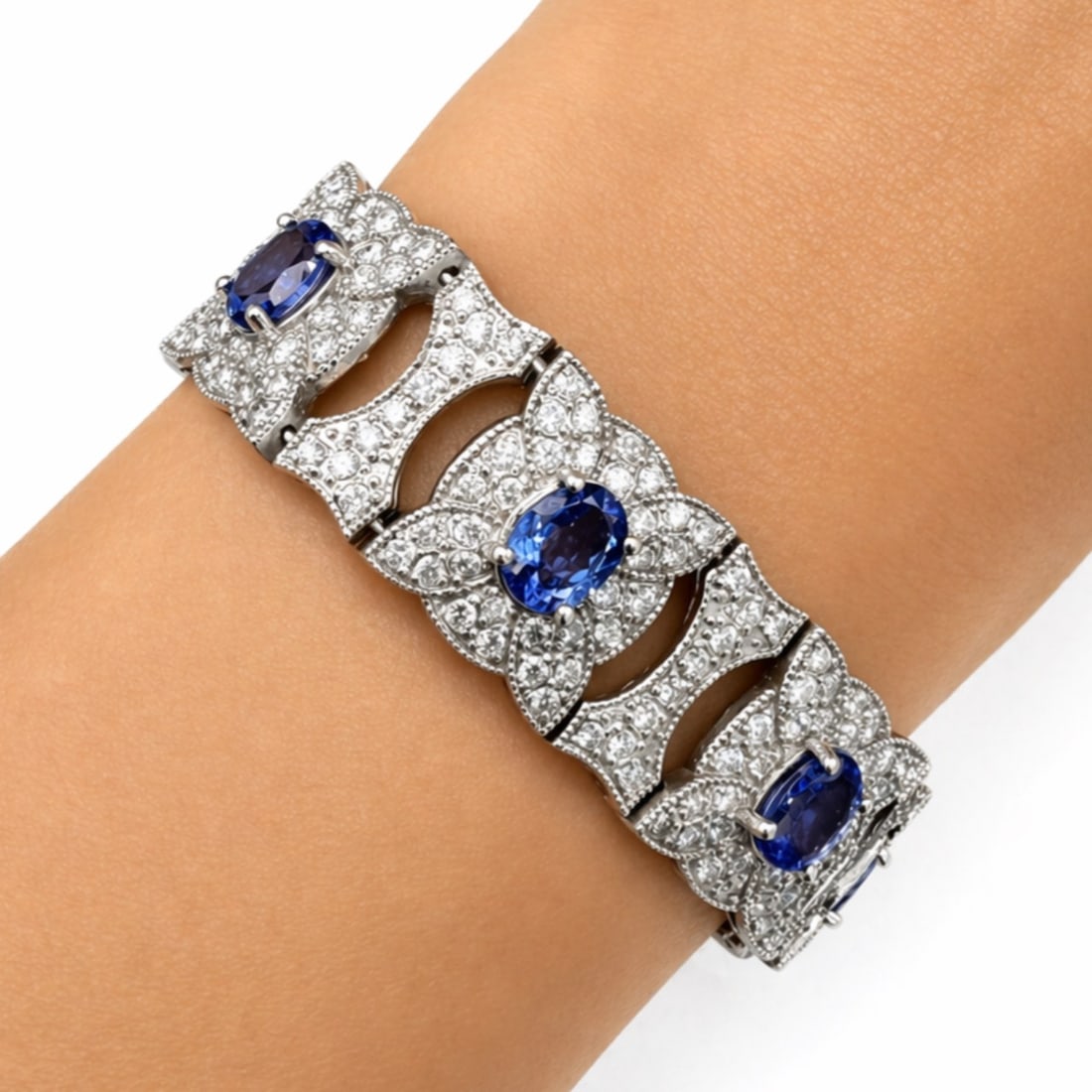 14K White Gold Bracelet with 30.00 CTW in Tanzanite & Diamond: 14K White Gold Tanzanite & Diamond Bracelet, weighing 36.4 grams, set with 8 tanzanite totaling approx. 20.00 cts in vivid blue-violet, each framed in a bold floral-style link and surrounded by 336 di