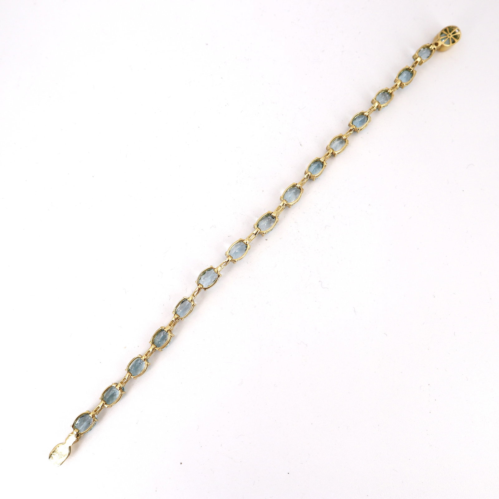 18K Yellow Gold Bracelet with 26.00 CTW in Aquamarine & Diamond: 18K yellow gold aquamarine & diamond bracelet, weighing 12.0 grams, set with 16 oval Brazilian aquamarines totaling approx. 13.50 cts for luminous, ocean-blue color along the wrist. Accenter by 14 bag
