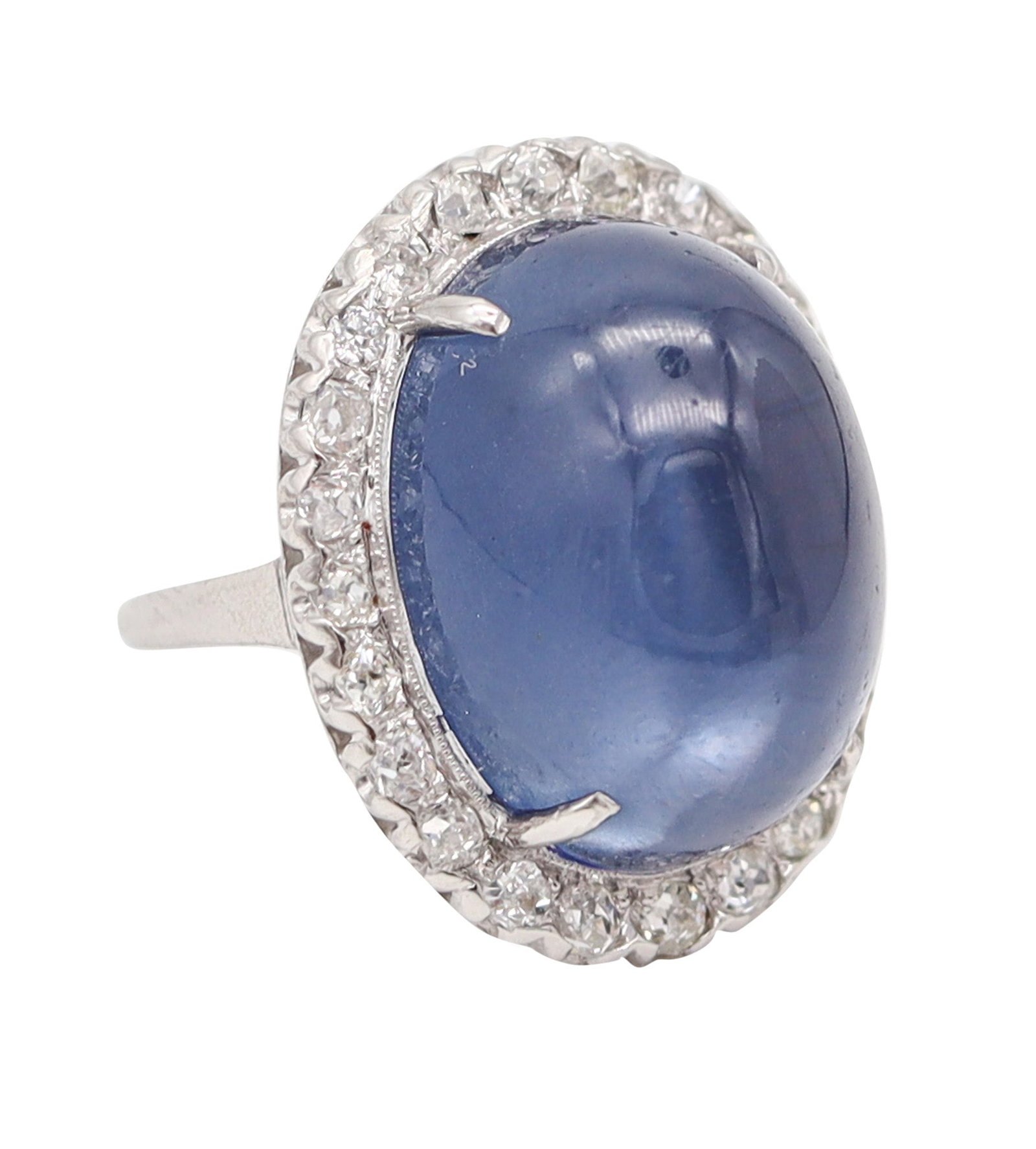 ART DECO 1930 Platinum Cocktail Ring With Star Blue Moonstone & Diamonds: United States, Art Deco (c. 1925–1930). Handcrafted ring in .900 platinum/iridium with a classic domed cluster, centered by an oval cabochon star blue moonstone (18 x 14 x 10 mm) weighing approx. 17