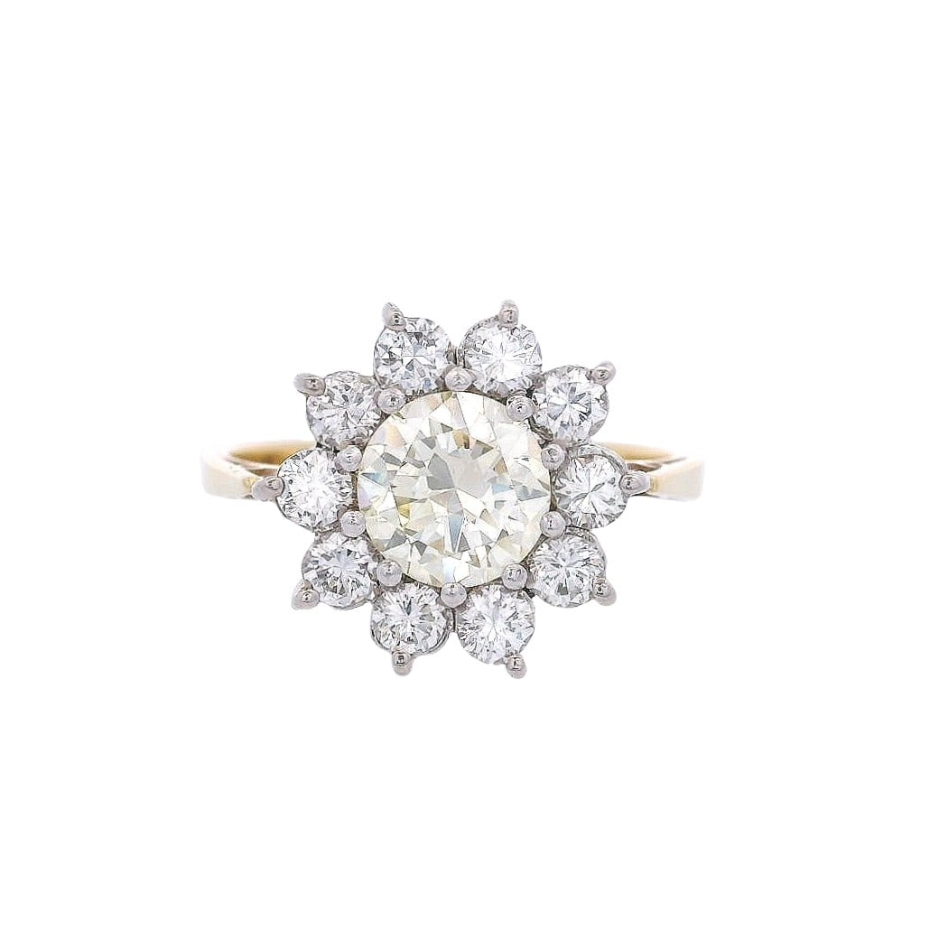 18kt Gold Cluster Diamond Ring with 1.06 Cts in Fancy Light Yellow Diamond: 18kt yellow & white Gold Cluster Ring featuring a center Fancy light yellow Round cut Diamond of Approx. 1.06 carats. Surrounded by 10 Round cut Diamonds weighing together Approx. 1.00 carats. H color