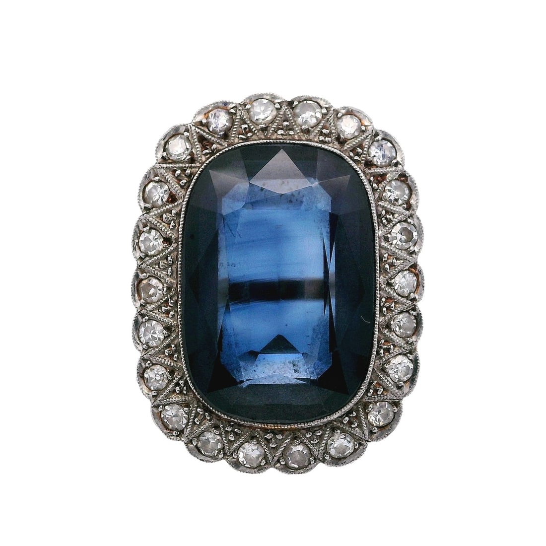 18K Yellow Gold & Platinum Ring with 12.35 CTW in Synthetic Sapphire & Diamond: Antique 18K yellow gold and platinum Princess Diana–style ring featuring a vivid synthetic blue sapphire center stone weighing approximately 11.70 carats, framed by a diamond halo of 22 single-c